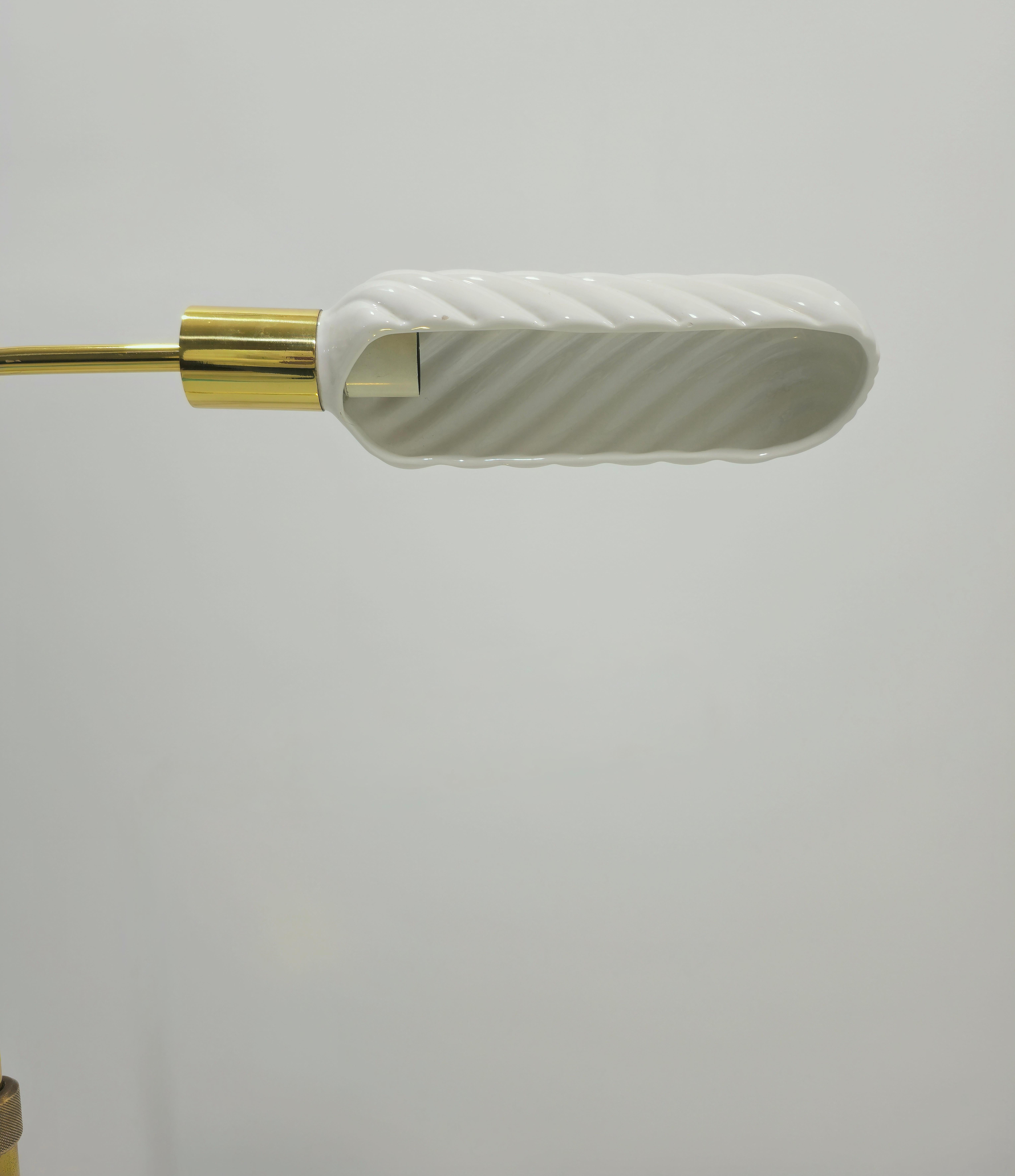 Rare lampadaire de Tommaso Barbi en laiton doré et diffuseur en céramique blanche. Il est doté d'un mécanisme de réglage en hauteur. Le diffuseur en céramique tourne également sur lui-même, orientant la lumière comme on le souhaite. Polyvalent. Un