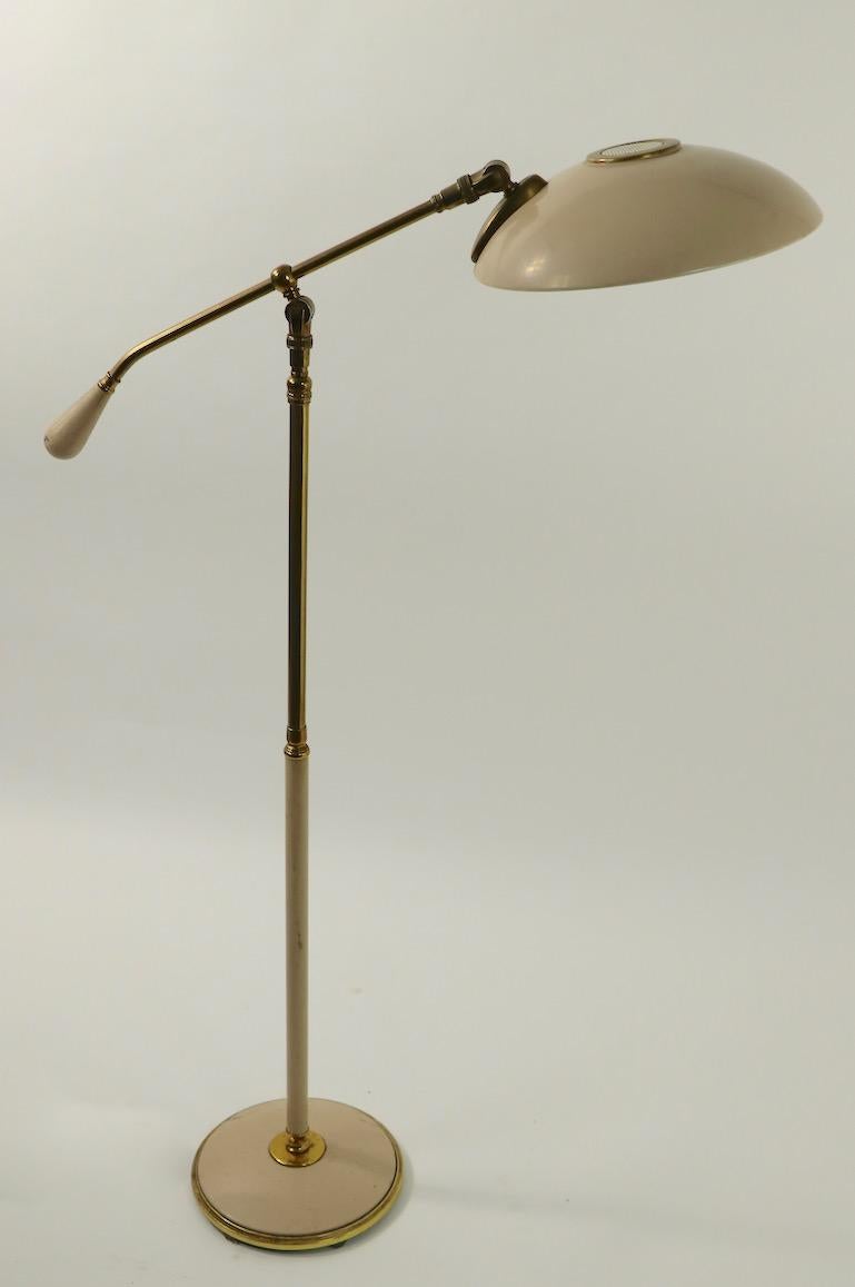 Adjustable floor lamp designed by Gerald Thurston for Lightolier. The lamp is adjustable in height (43 inch in lowest position x 53 inch in highest position) the disk saucer shade will tilt and pivot to direct the light, the counter weight arm also