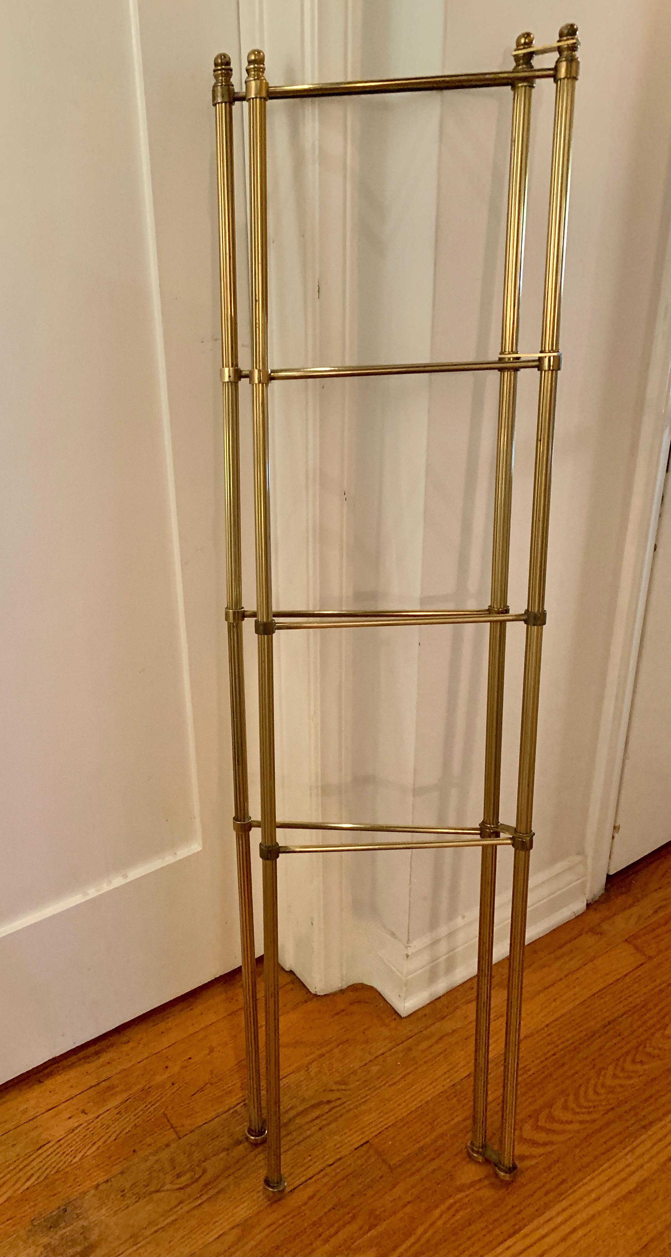 A wonderful vintage brass towel rack with four rods on each side, for a total of 8 places to store towels or other folding textiles. The rods are not adjustable but each side bends to fold accommodating the space it is in, or flat for easy storage.