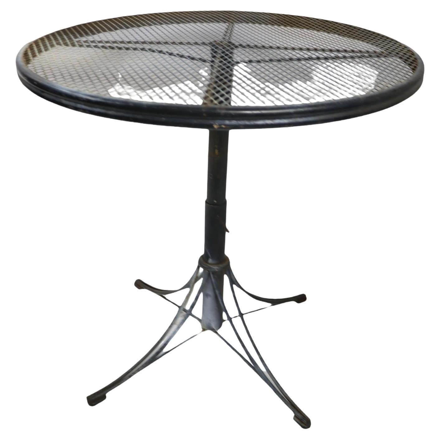 Unusual adjustable table of wrought iro=bn and metal mesh, made by Homecrest , Bottemiller ca. 1960's. This example features an adjustable center pole, allowing the height to extend from a coffee table height ( 17