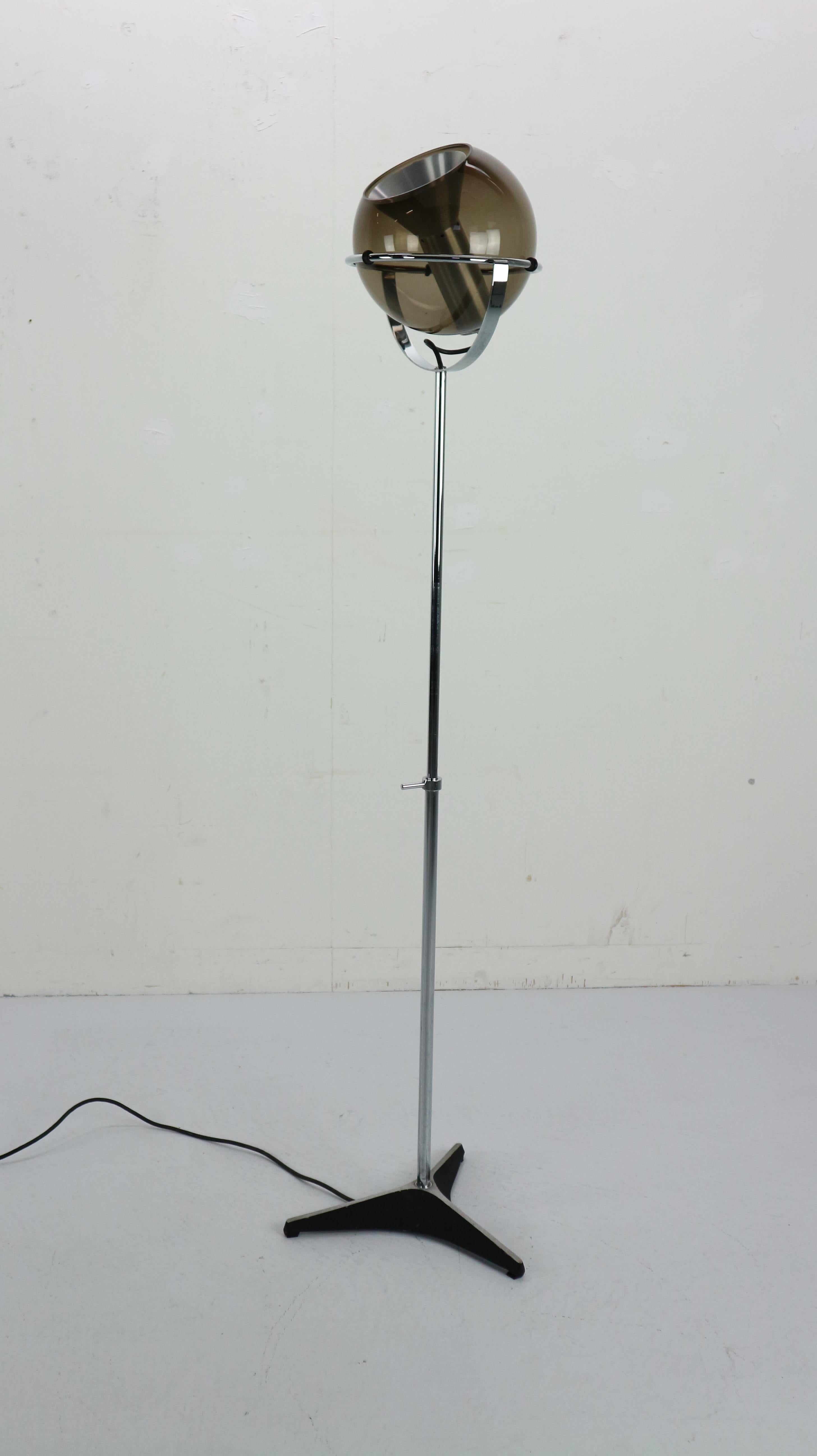 Globe floor lamp by Frank Ligtelijn for RAAK, designed in 1960s Netherlands. Smoked glass globe on an adjustable chrome stand. Original 3 star iron base and foot switch with original wiring.
Floating smoked glass globe rotates in almost any