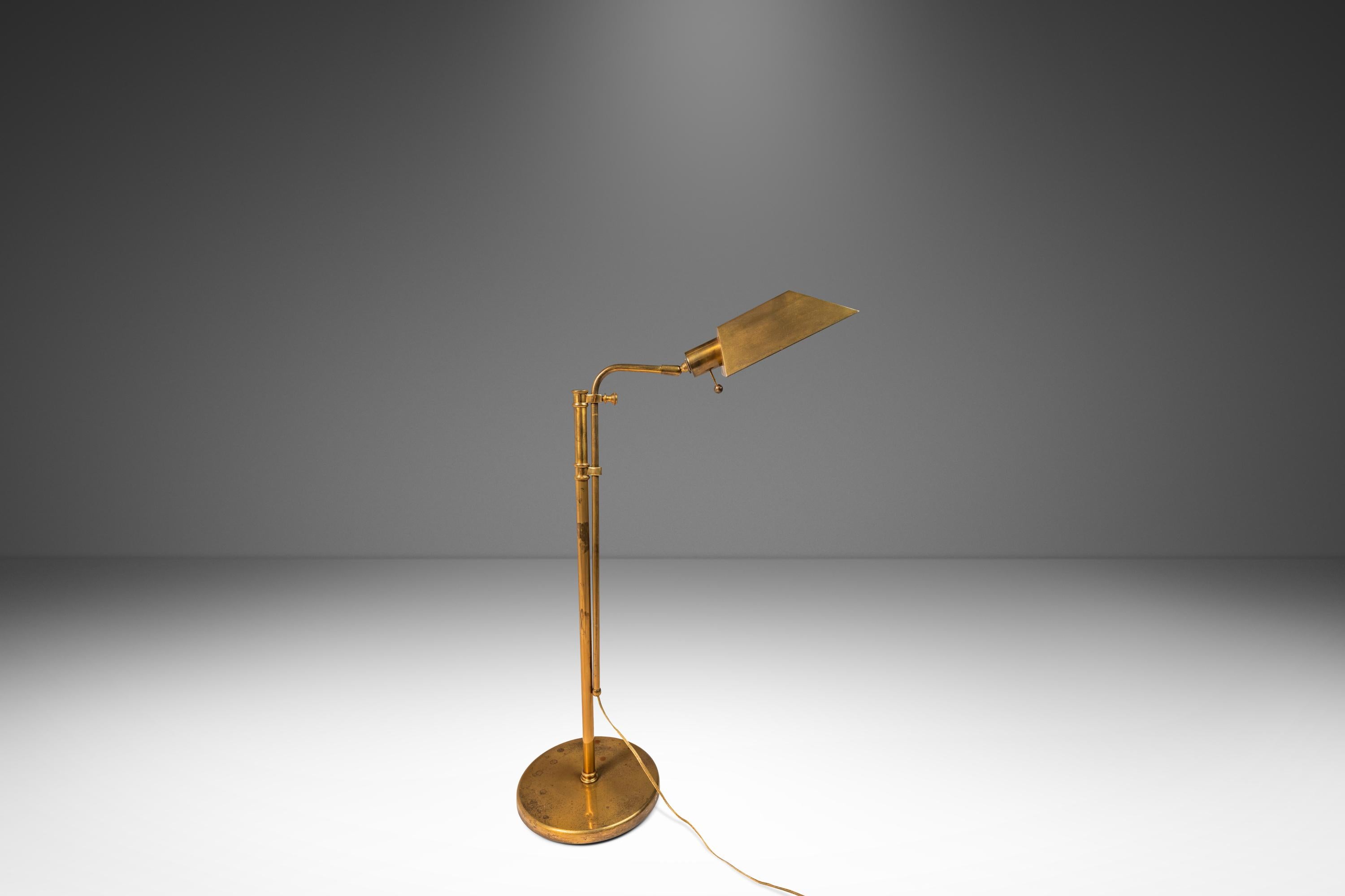  This sophisticated adjustable floor lamp, attributed to the renowned lighting design firm Koch & Lowy, captures the sleek functionality and minimalist elegance of mid-century modern design from the 1970s. Crafted in the USA, the lamp features a