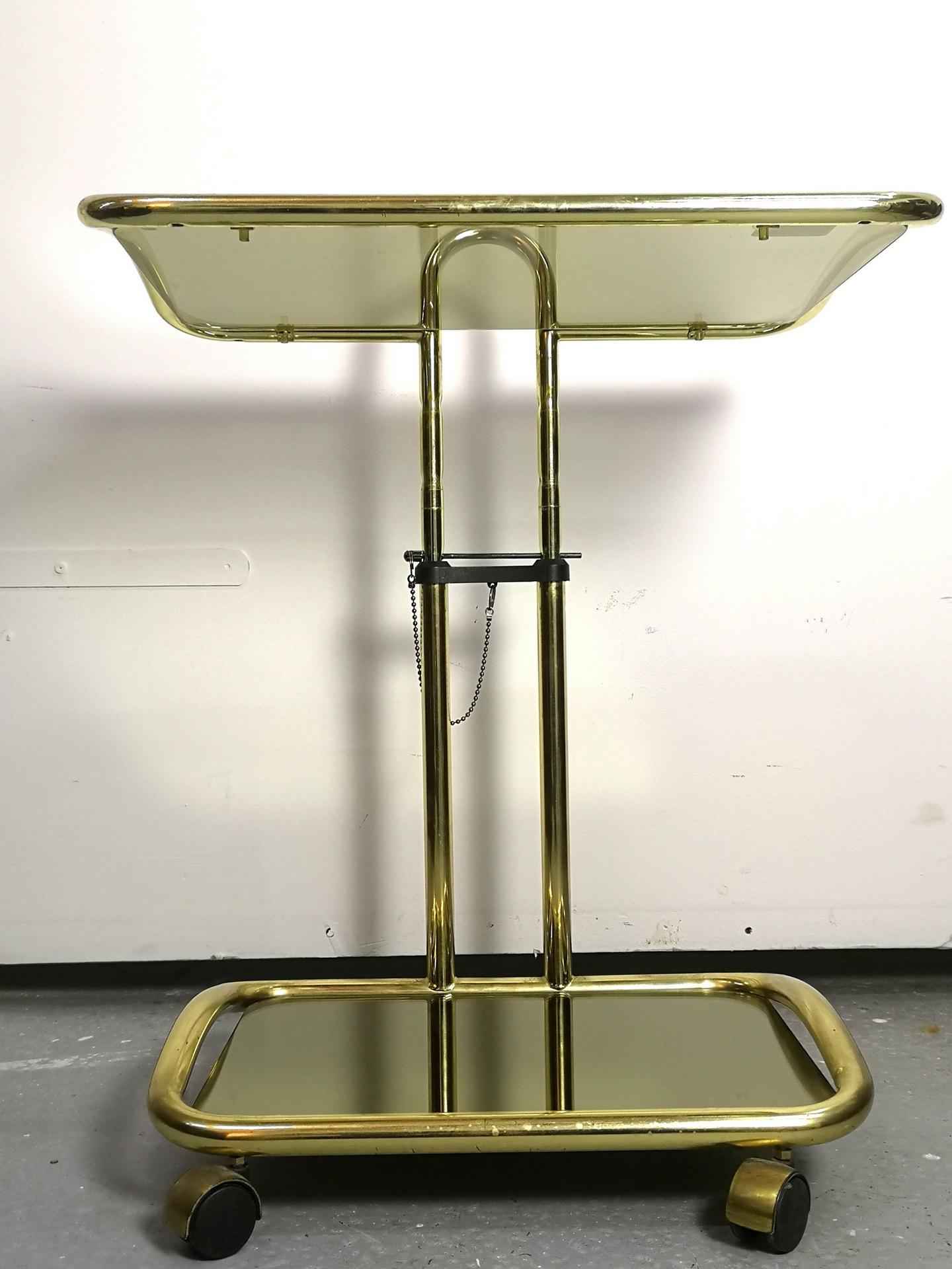 Italian Modern, this original piece is from Morex- a 1970s brass plated bar table on wheels. The height is adjustable, and still features the original Morex sticker. Rare piece in Hollywood regency style.