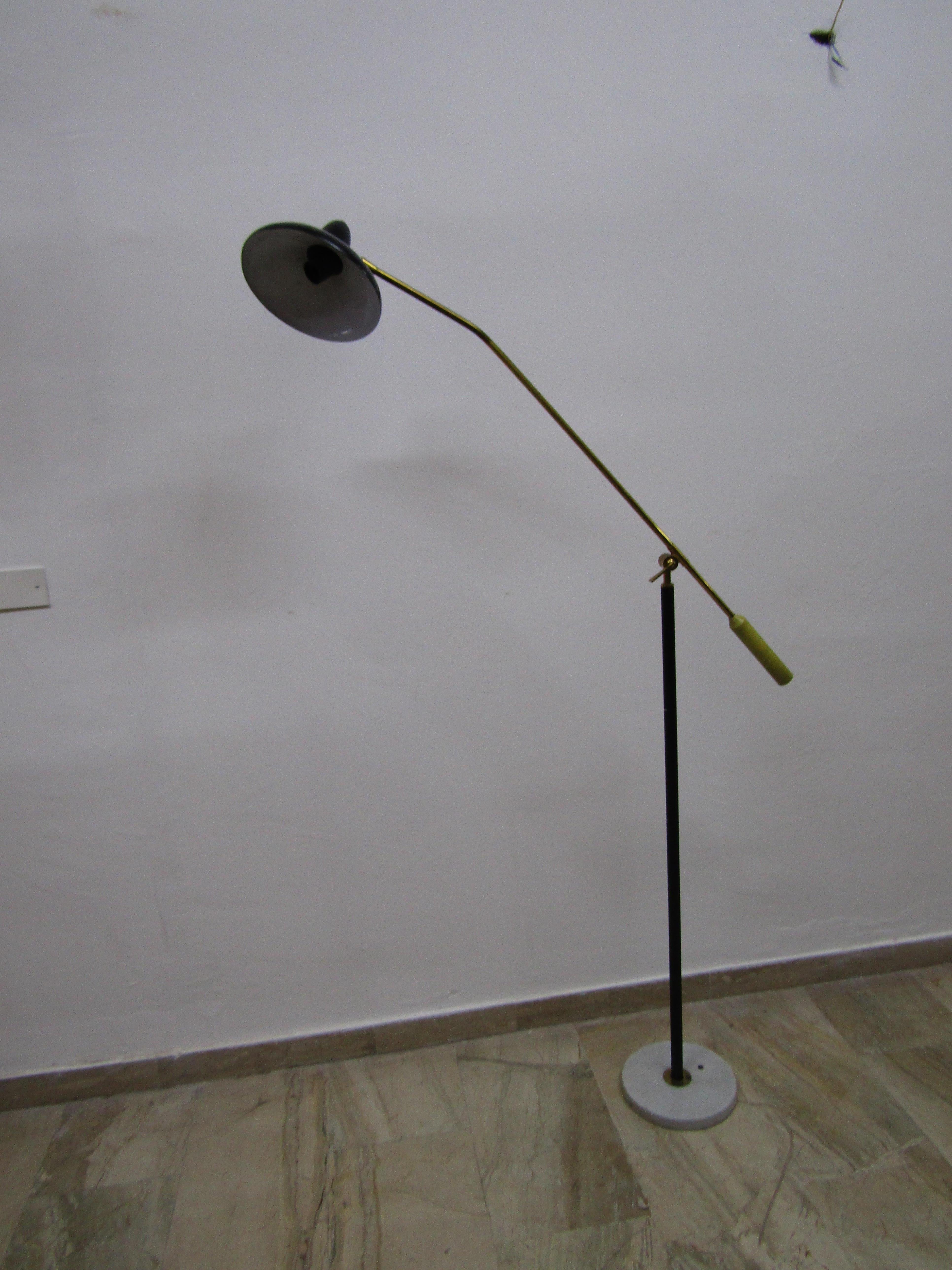 A rare adjustable floor lamp in Stilnovo style. Original shades in painted metal with brass arms and marble base.