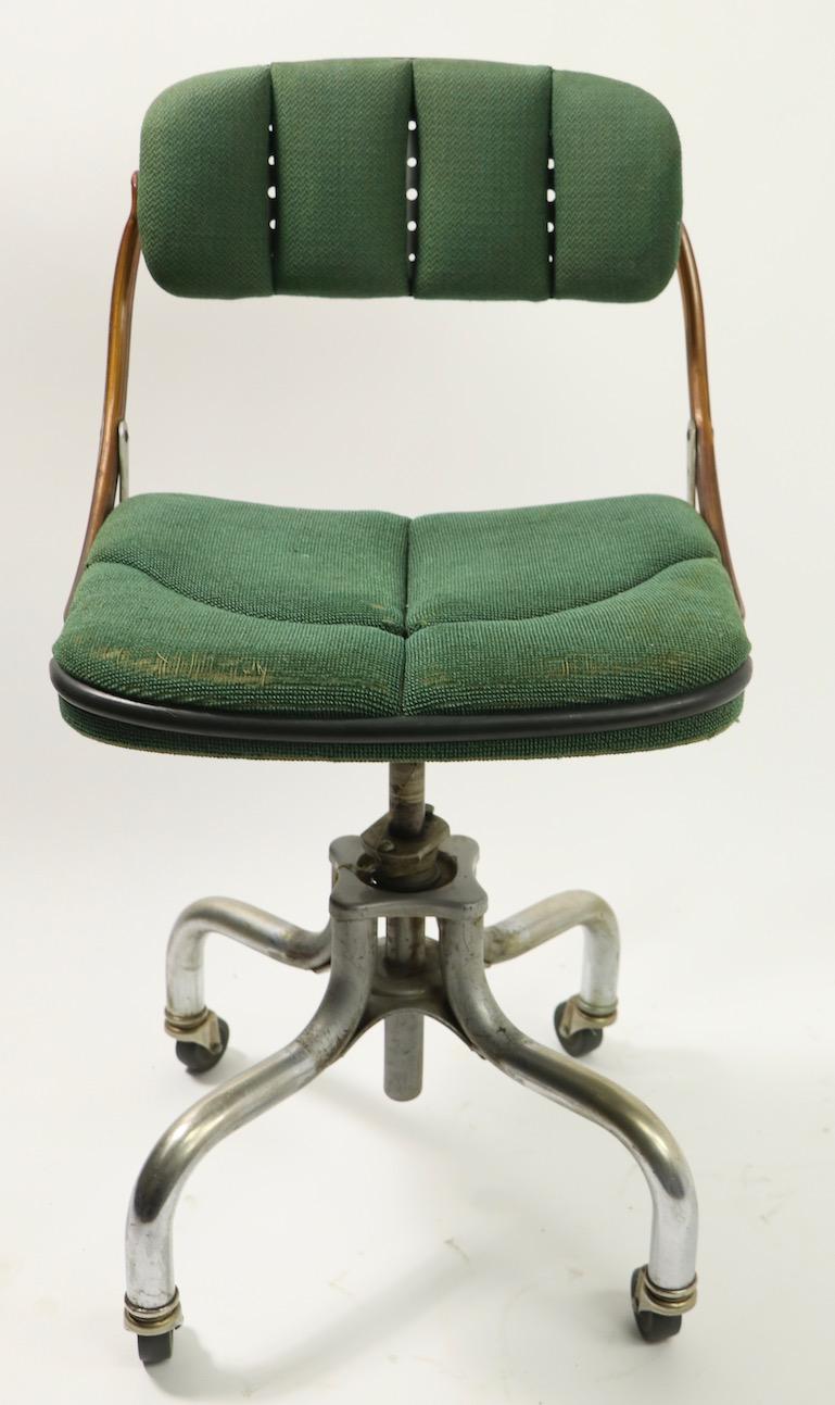 Adjustable Industrial swivel desk / office chair by Do More. This example has its original green fabric upholstered seat and backrest, seat shows wear spot - please see images. The backrest pad will tilt to adjust in position, as shown, chair