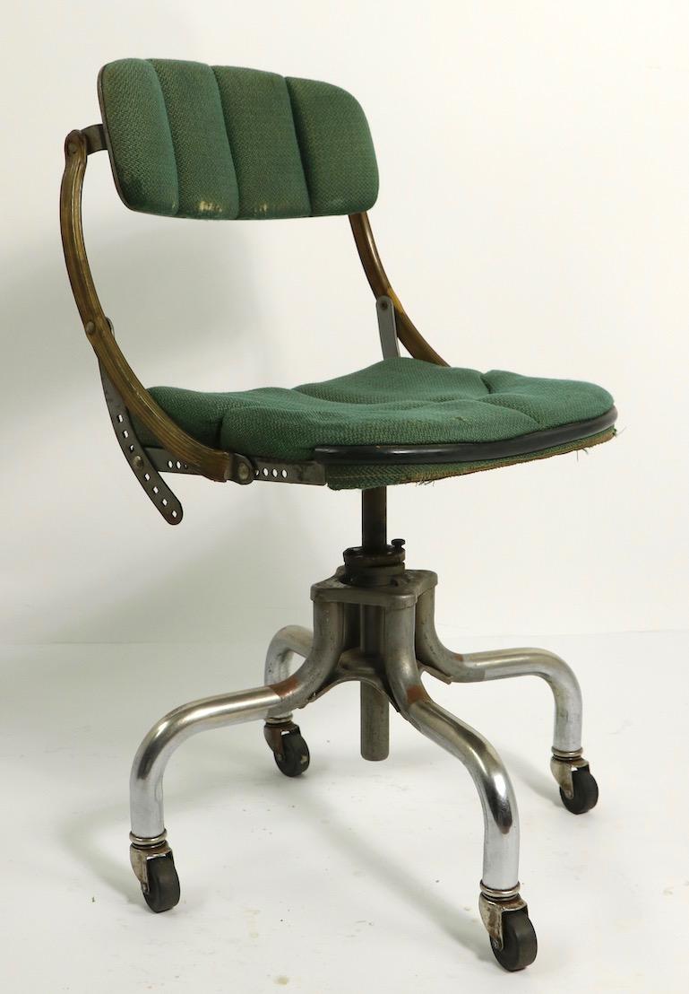 Adjustable Industrial swivel desk / office chair by Do More. This example has its original green fabric upholstered seat and backrest, seat shows wear spot - please see images. The backrest pad will tilt to adjust in position, as shown, chair