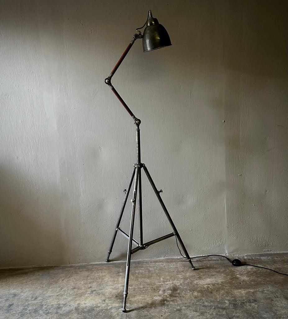 1970s English Industrial tripod floor lamp in nickel and teak. A versatile light fixture, gritty and modern. 

England, circa 1970

Dimensions: 20-30W x 20-30D x 56-80H.