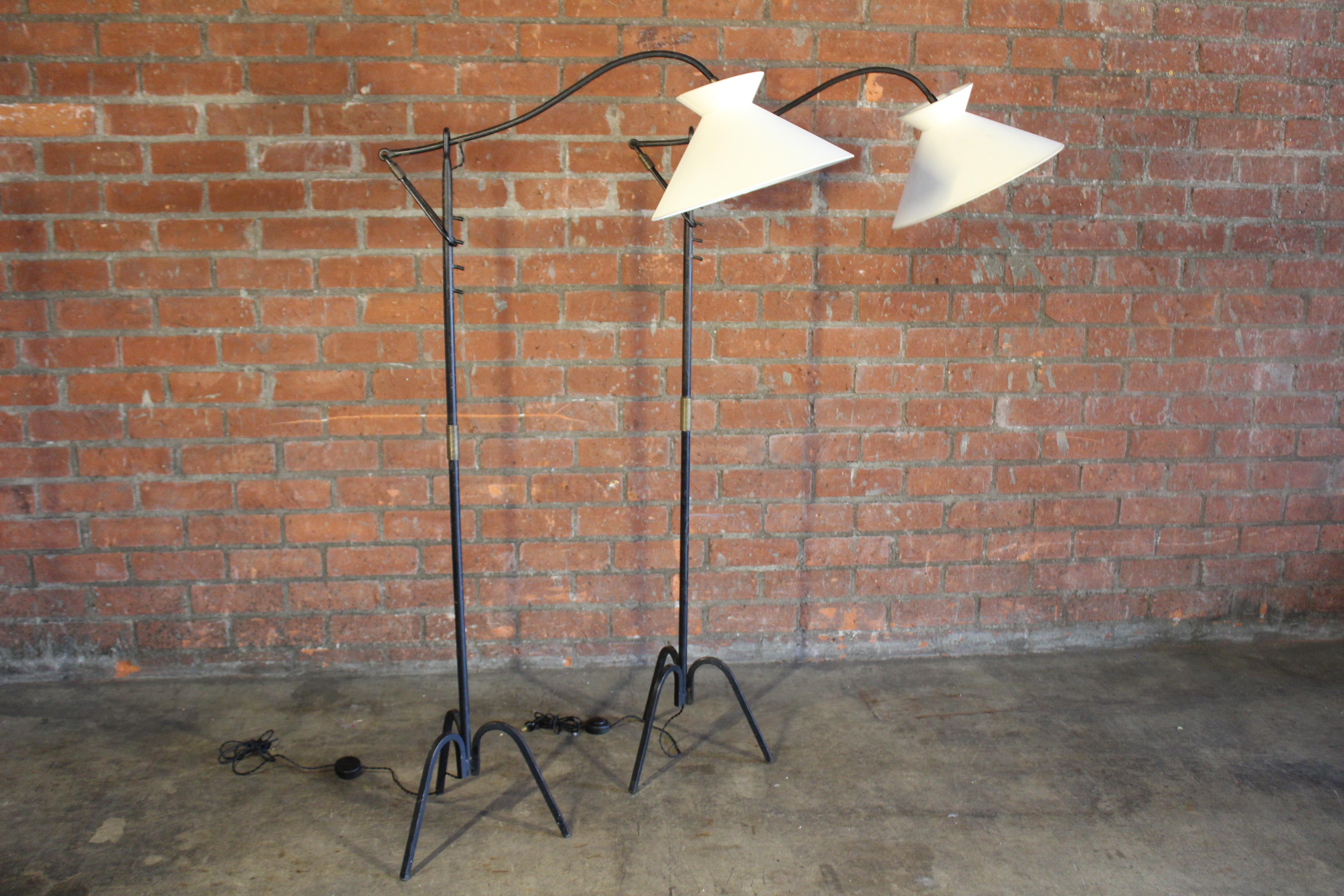 Vintage iron floor lamp, often attributed to Jacques Adnet. Made of solid heavy iron and with a lovely brass wrapped accent around the stem. The double cone shade is in silk and newer but have been made to mimick the style of the period. Newly