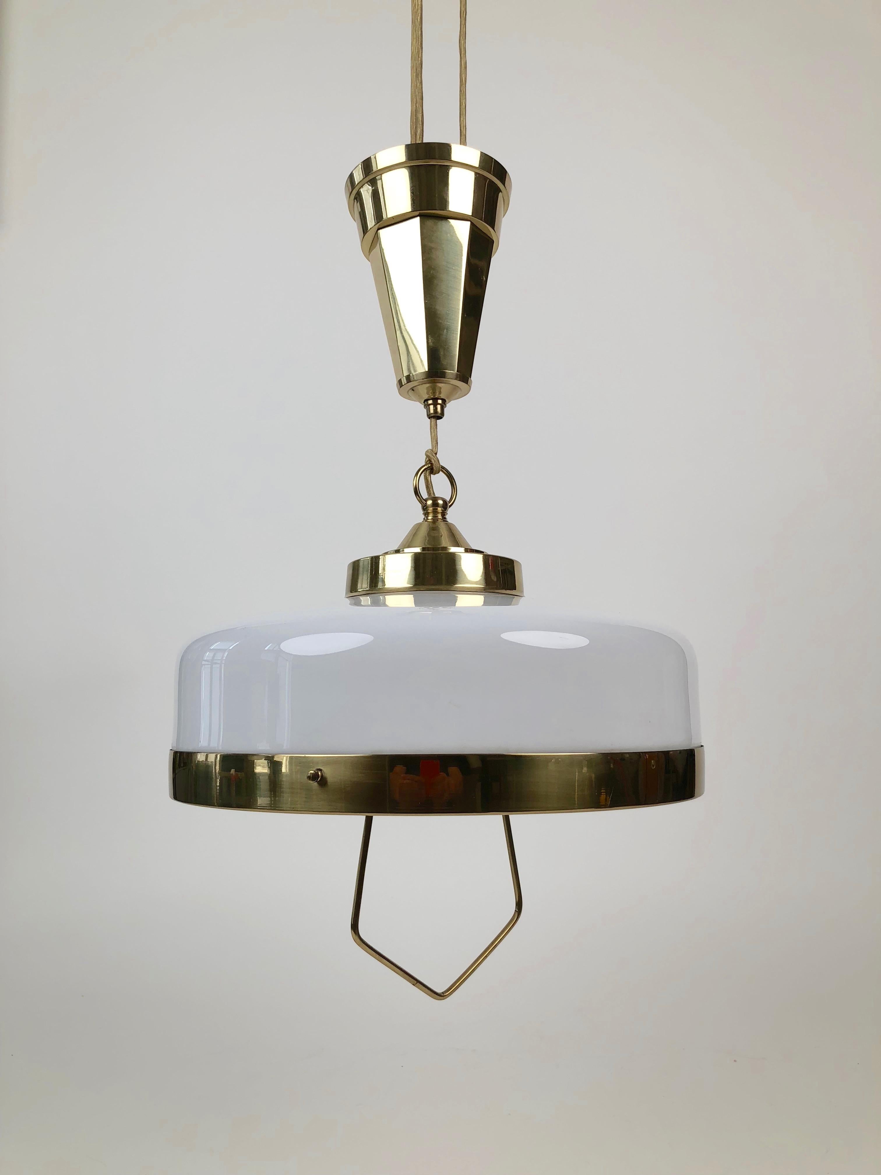 Adjustable jugendstil chandelier with white opaline glass. It was produced in Austria, circa 1923. The electrical wiring was replaced in the
late 1990s. It comes with the original wooden ceiling cup that goes between the ceiling and brass cup. This