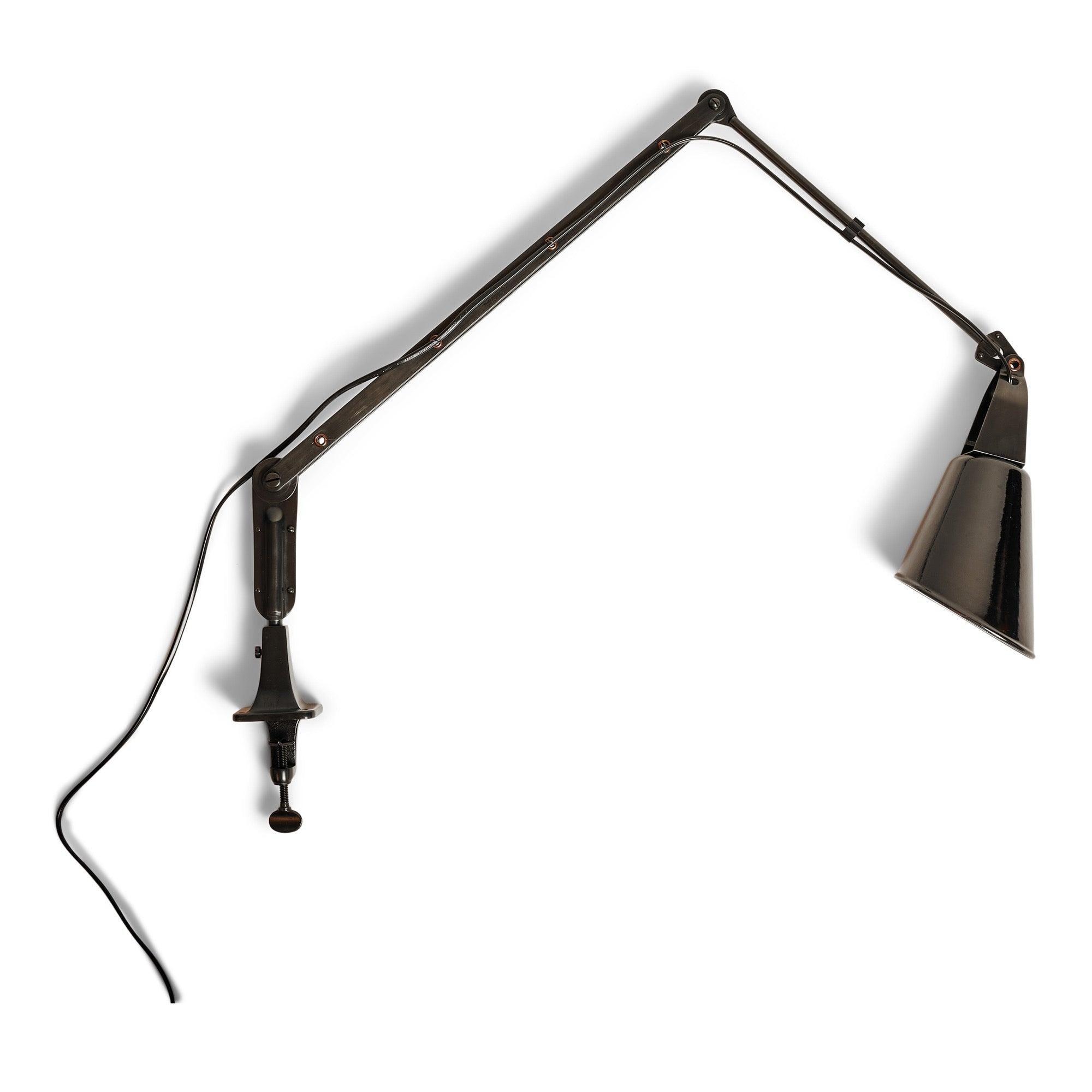 A machinist lamp with a clamp base, featuring an adjustable arm and an enameled swiveling shade.
