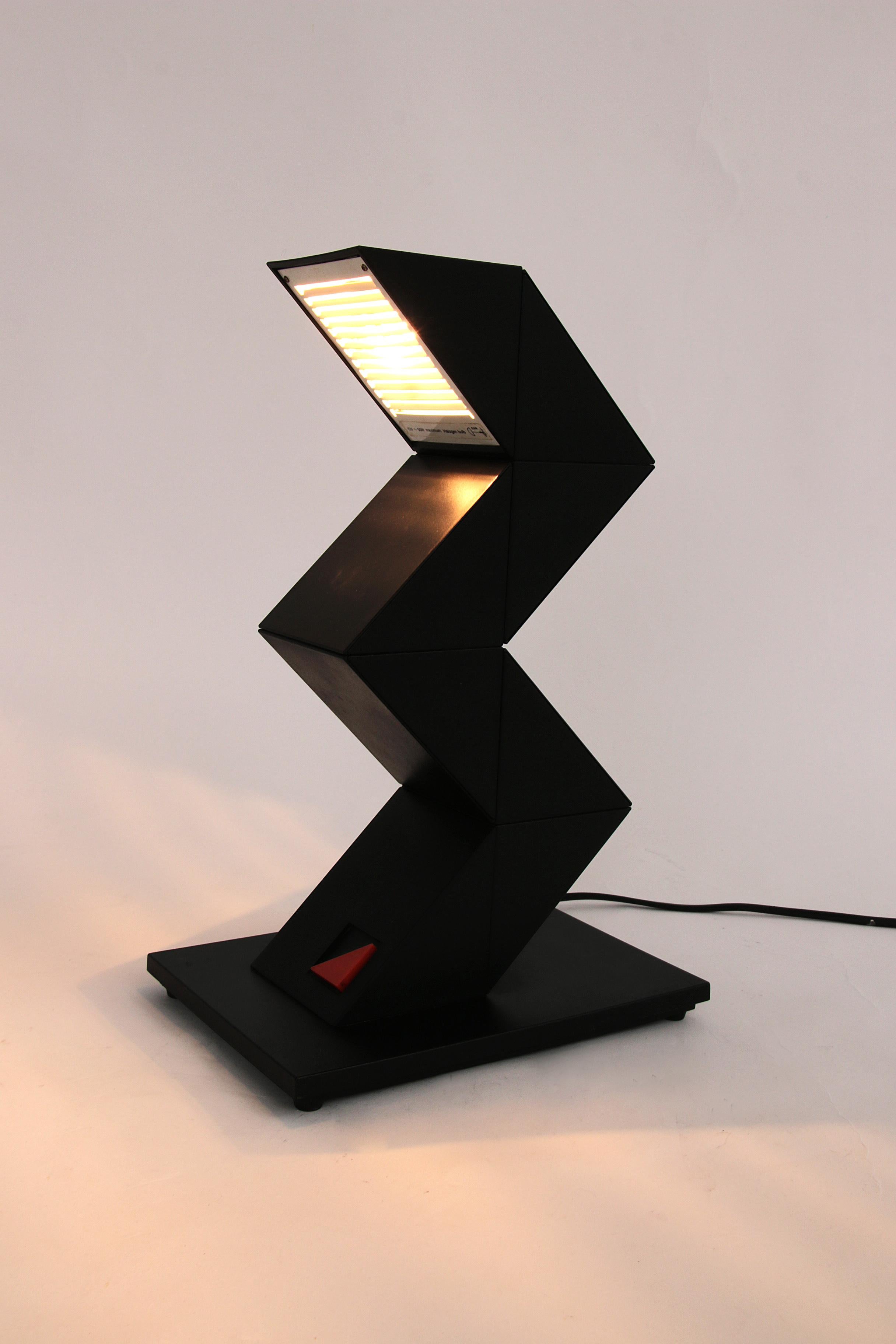 Découvrez la polyvalence de la lampe Massive Zig Zag, une pièce unique d'éclairage design des années 1980. Cette lampe en plastique noir n'attire pas seulement l'attention, elle est aussi très fonctionnelle grâce à ses 8 éléments triangulaires