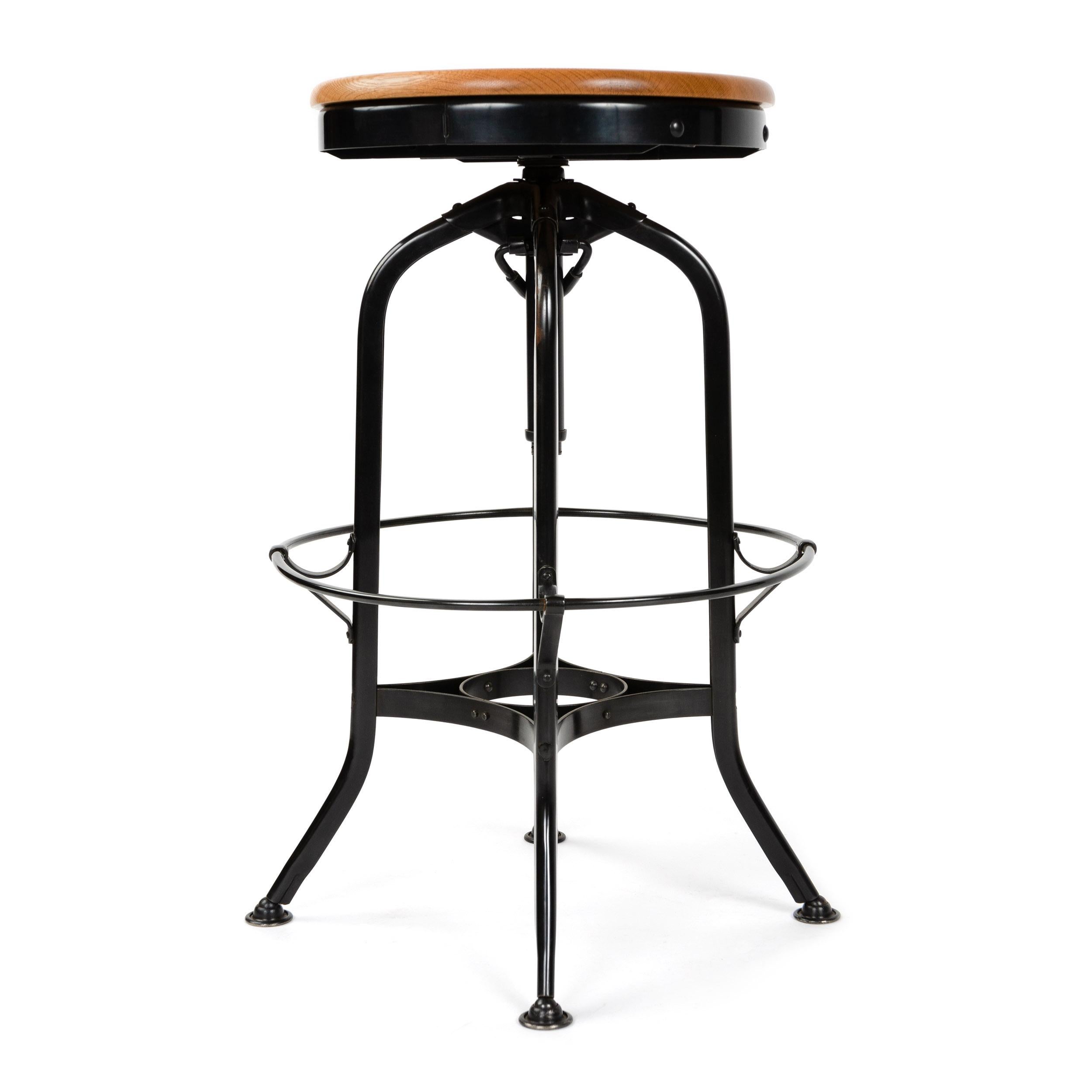 A black patinated steel adjustable-height stool with an oakwood seat and a ring footrest. Designed and manufactured by Toledo in the USA, 1930s.
Adjusts from 25.5