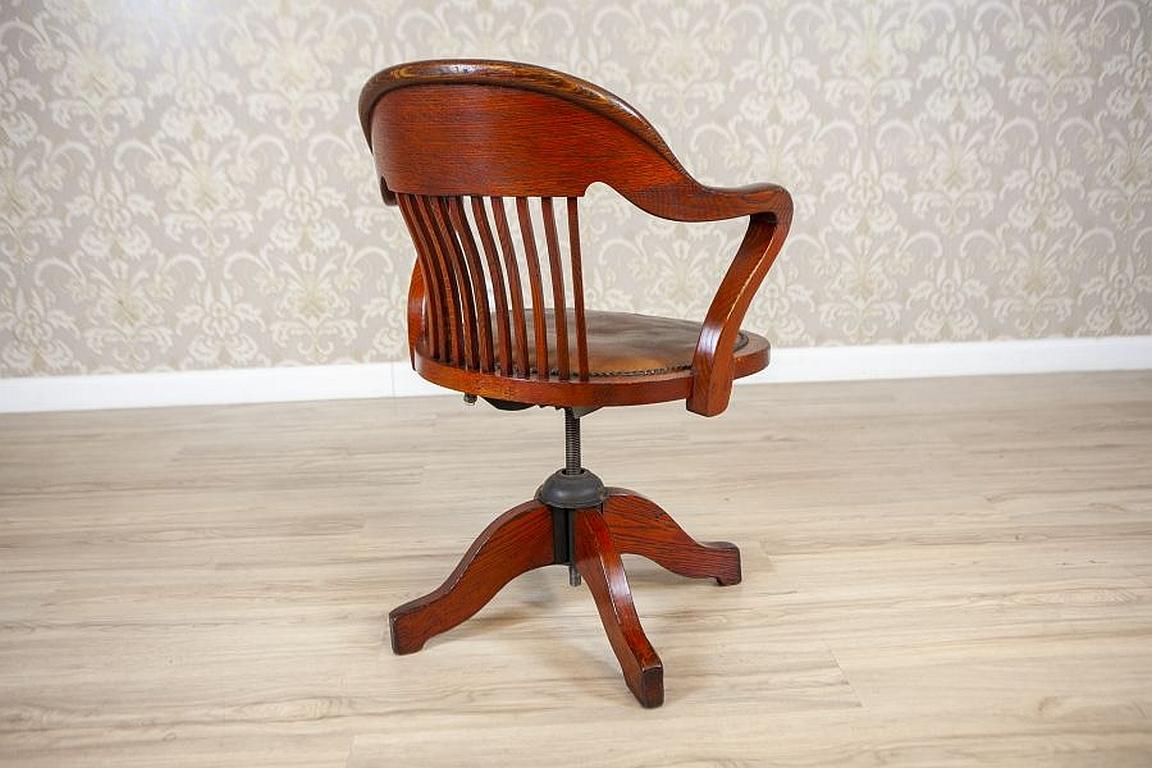 Adjustable Oak Swivel chair From the Early 20th Century

We present you this oak swivel chair with armrests that smoothly turn into supports. The backrest is rounded, with vertical slats. Furthermore, the seat is upholstered with leather and