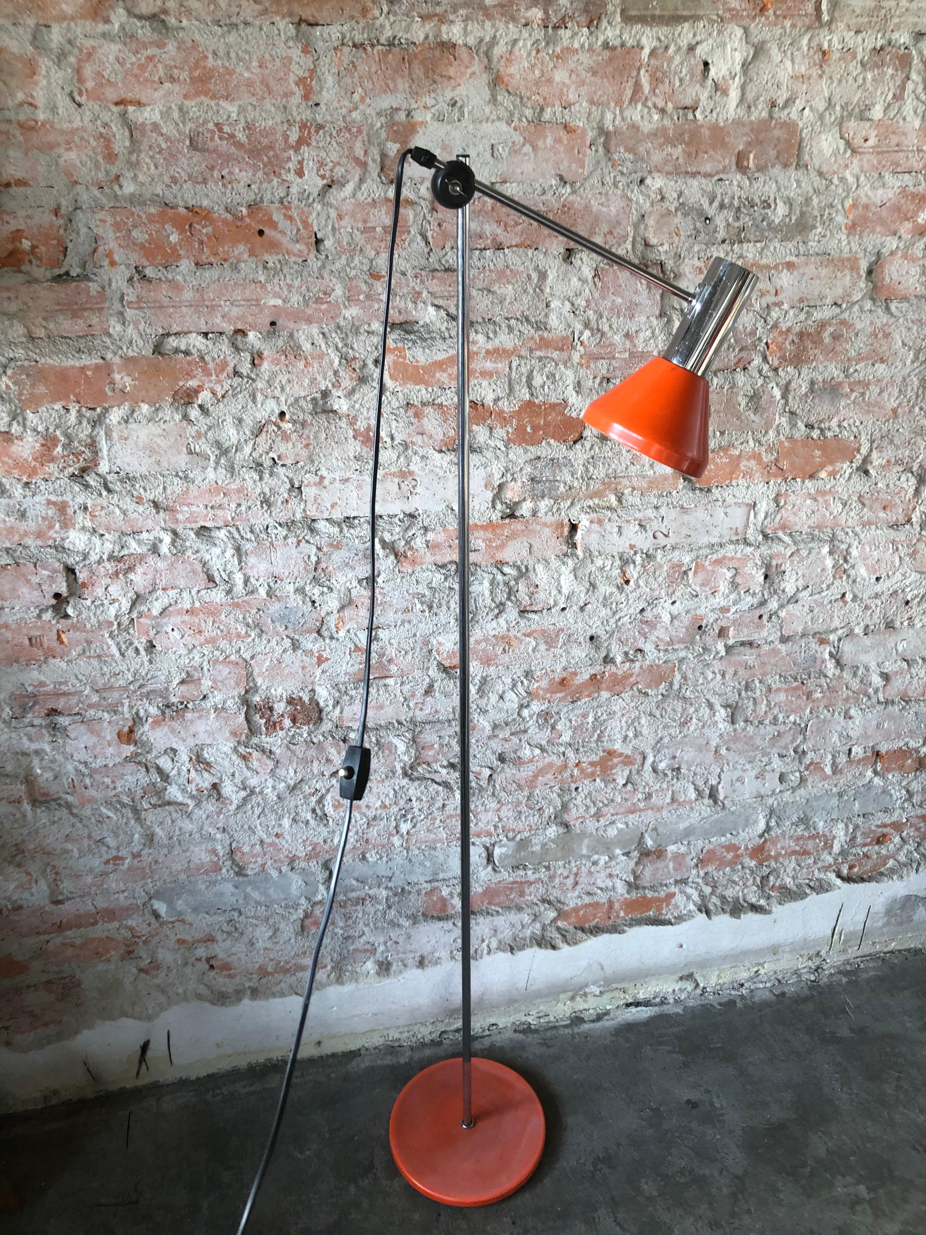 This floor lamp with adjustable height and angle was made during the 1960s. It is made of metal with orange lacquer and chrome. The piece is fully functional and is in a good vintage condition.