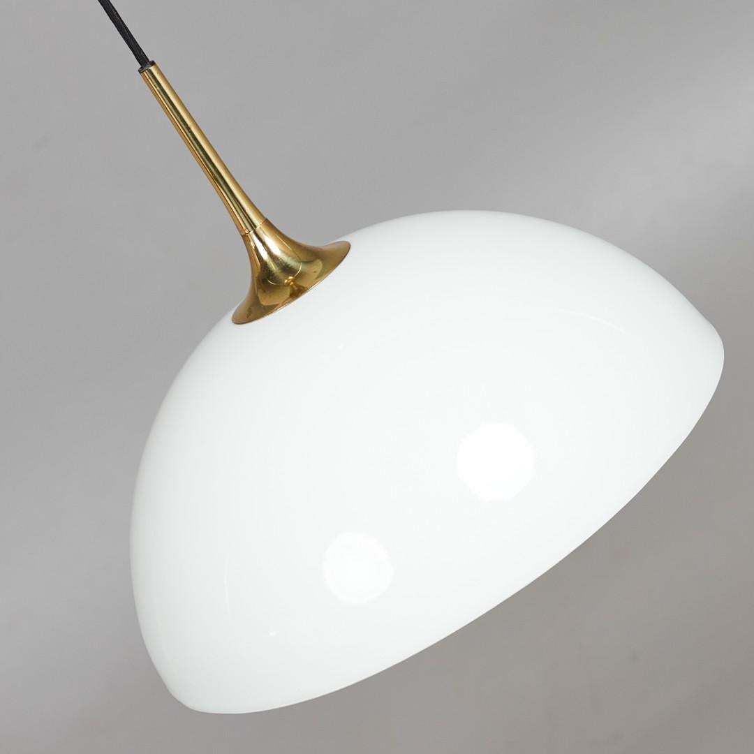 Adjustable brass/chrome counterweight pendant lamp with a opaline glass shade and fitted with one E27 socket. Designed in the 1970s by Florian Schulz in Germany.
 