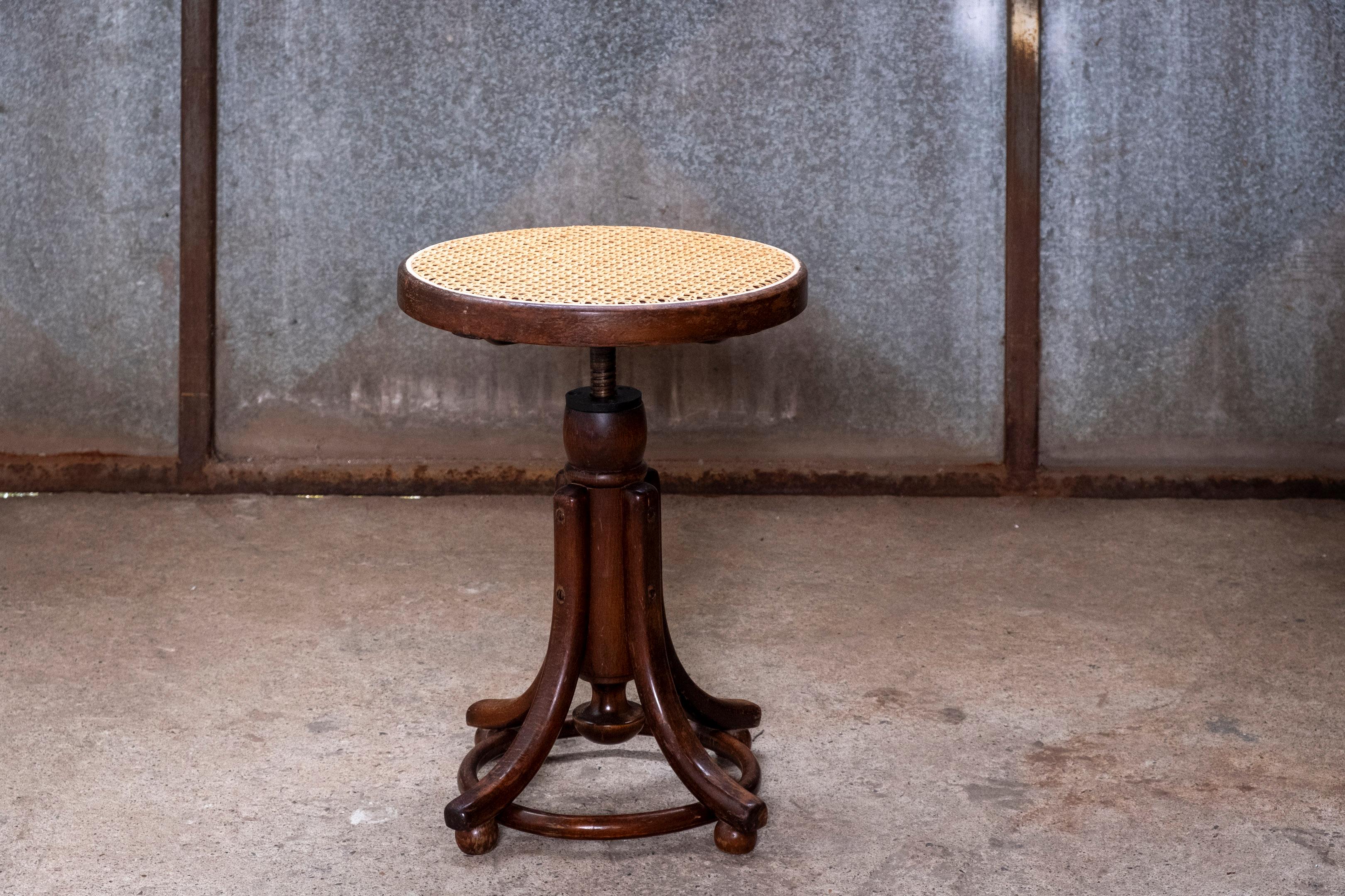 Adjustable piano stool in the style of Thonet. Has a wonderful color and patina. The seat height can be adjusted from 45cm minimum to a maximum of 56cm.
The seat has been restored with new wicker.