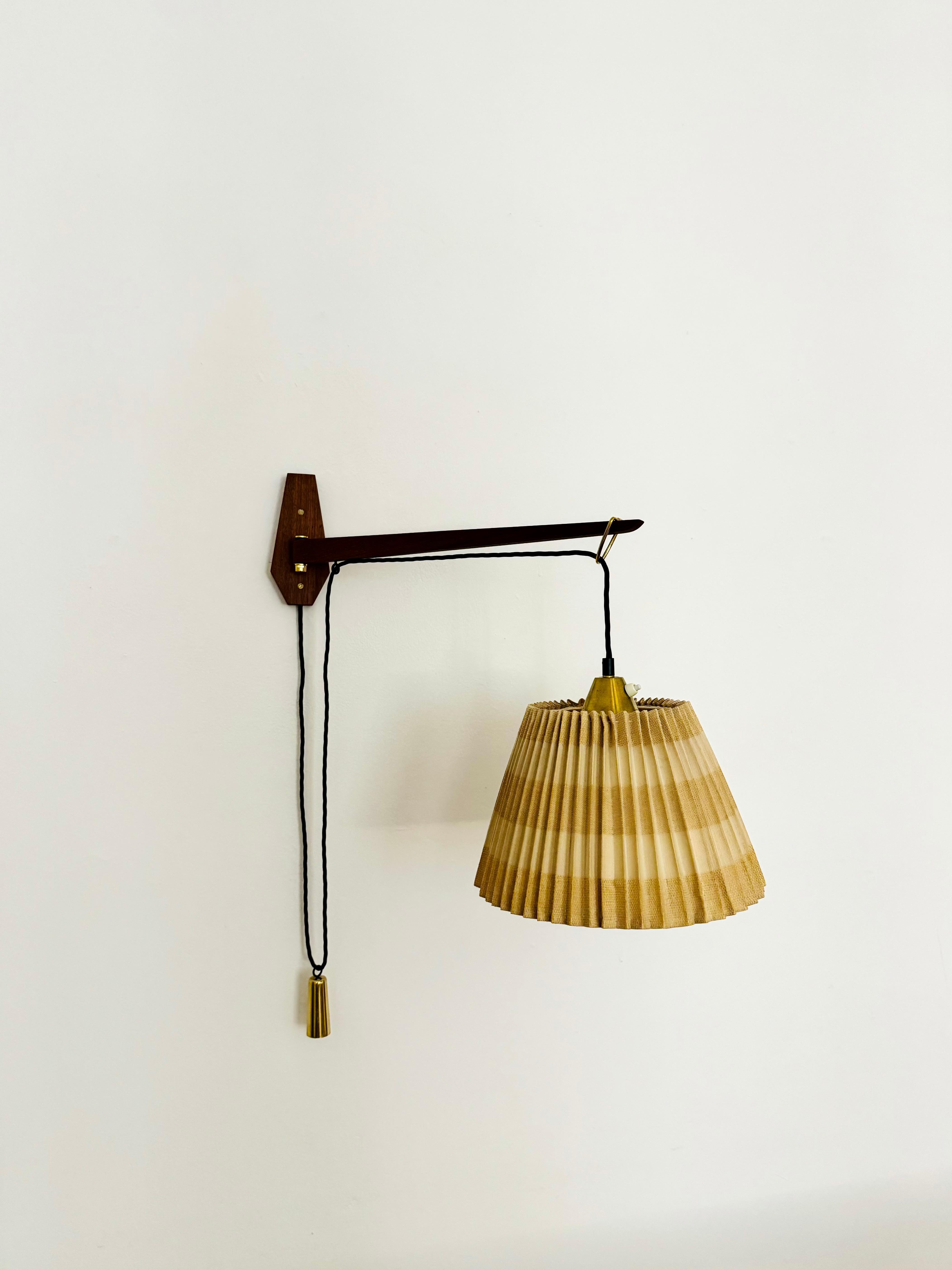 Affascinante lampada da parete regolabile degli anni '50.
Un design eccezionale e minimalista con un aspetto incredibilmente elegante.
Braccio girevole in teak molto bello.
Il paralume plissettato crea un meraviglioso gioco di luci e un'atmosfera