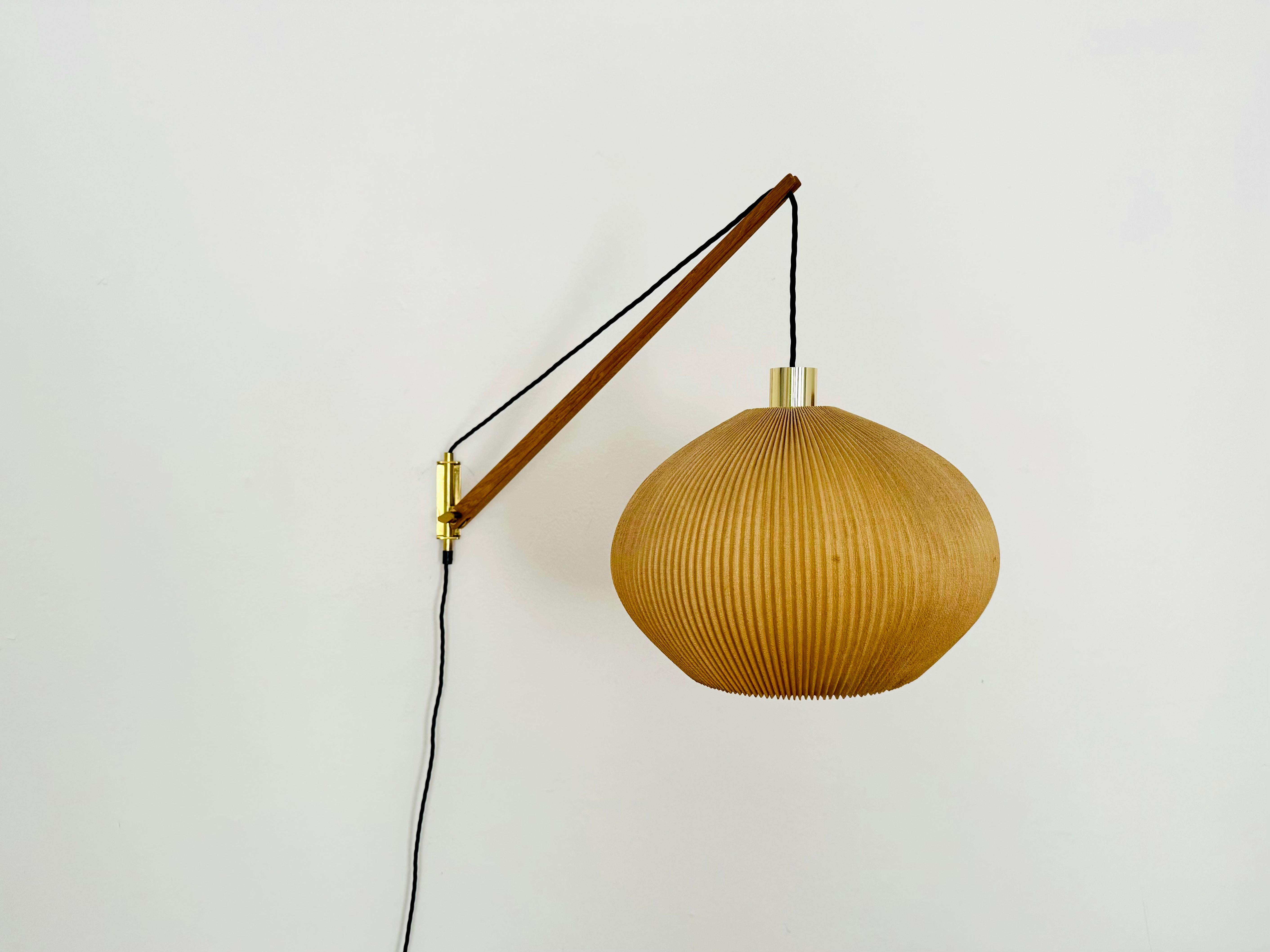 Wonderful pleated wall lamp from the 1950s.
Great and exceptionally minimalist design with a fantastically elegant look.
Very nice swivel arm made of oak wood.
The lampshade creates a very cozy atmosphere.
The brass details are very high