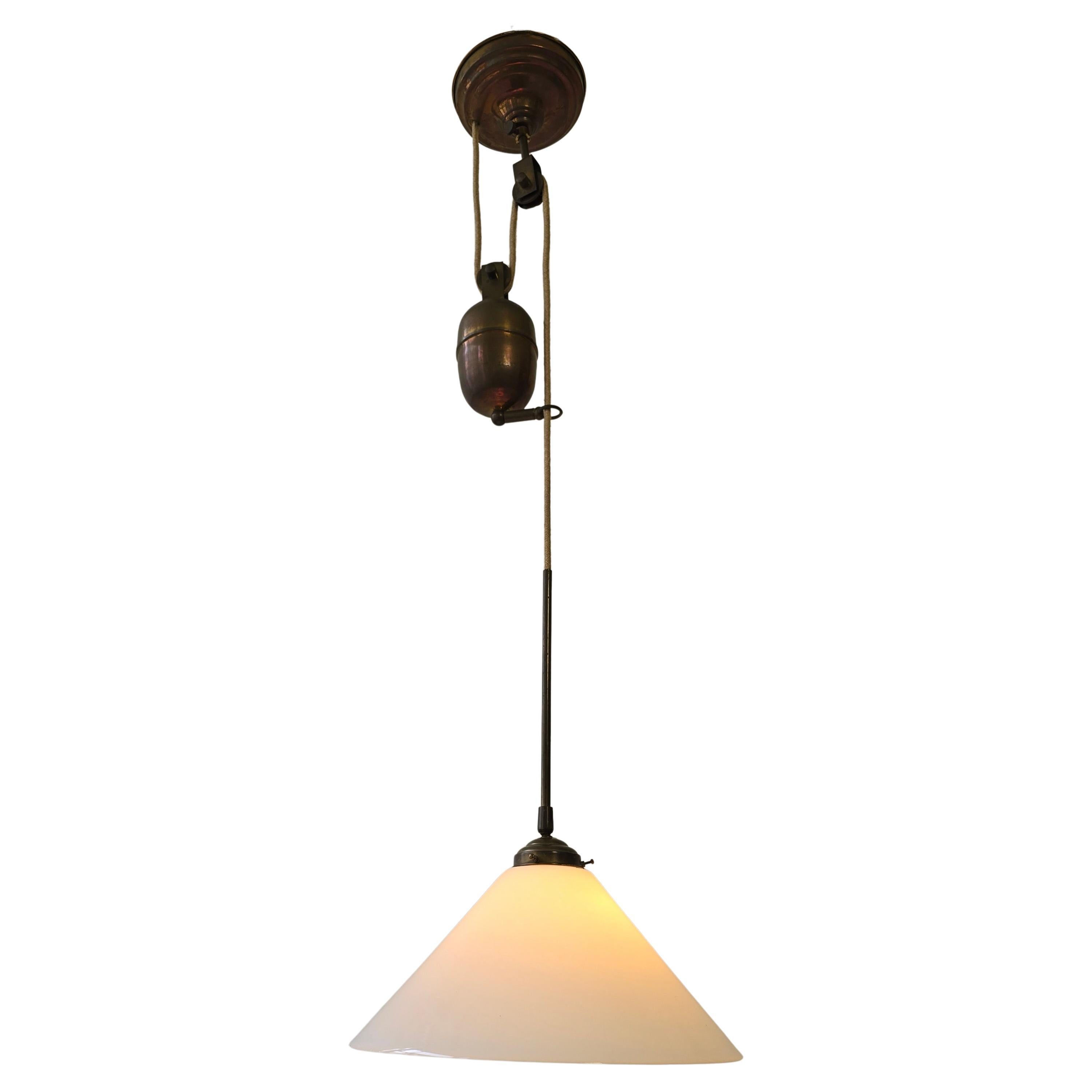 Adjustable Pulley Pendant Lamp in Copper and Opaline Glass, 1920s

This elegant and functional pendant lamp features a beautifully aged copper fixture paired with a pristine white opaline glass shade. Crafted circa 1920s–1930s, the lamp is equipped
