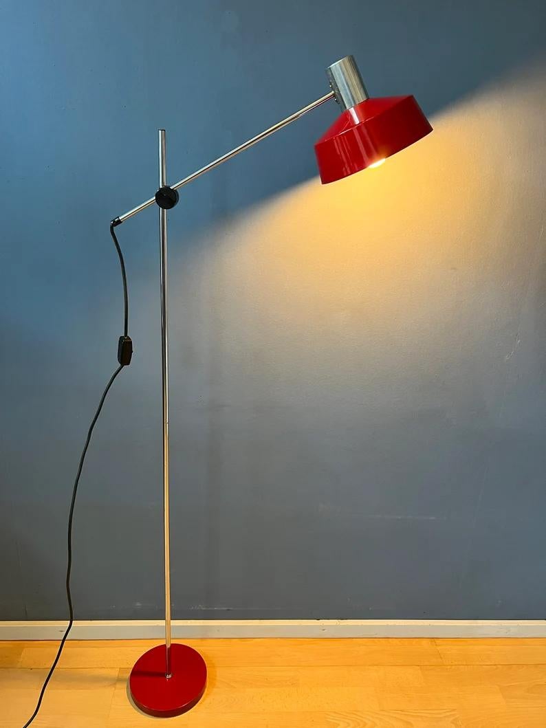 Flexible Anvia 'rod' floor lamp in red colour. The position of both the shade and the arm can easily be adjusted. The lamp has an aluminium shade. The lamp requires one E27 lightbulb and currently has an EU-plug (easily used outside EU with