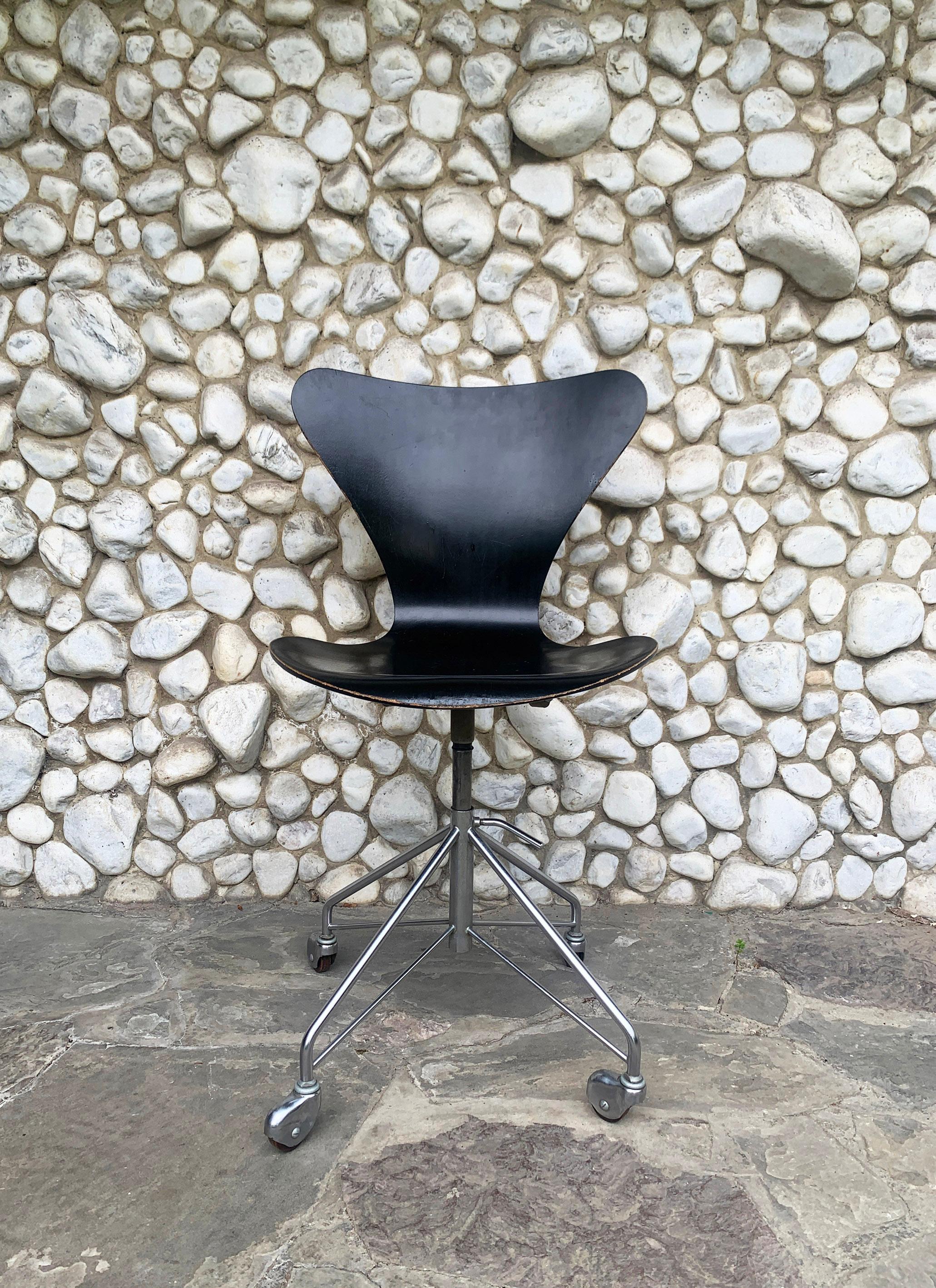 Swivel chair model 3117 in black plywood. Based on the 3107 chair designed by Arne Jacobsen in 1955. 

Produced by Fritz Hansen, Denmark in January 1965. 

Seating height adjustable from 44cm to 54cm. 

Seat in plywood, painted black (original