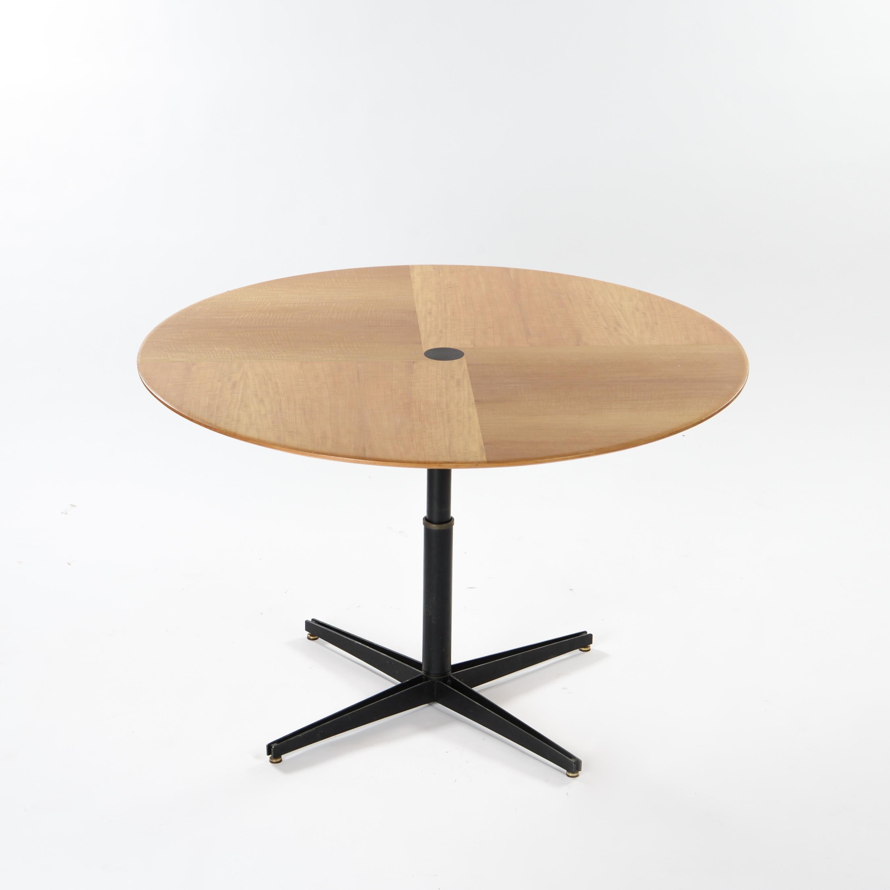 
Elegant adjustable table, model T41 by Italian designer Osvaldo Borsani.

The circular top in lemon veneer is in very good condition and rests on a black-lacquered metal cruciform central pedestal. 

The adjustable height, controlled by a