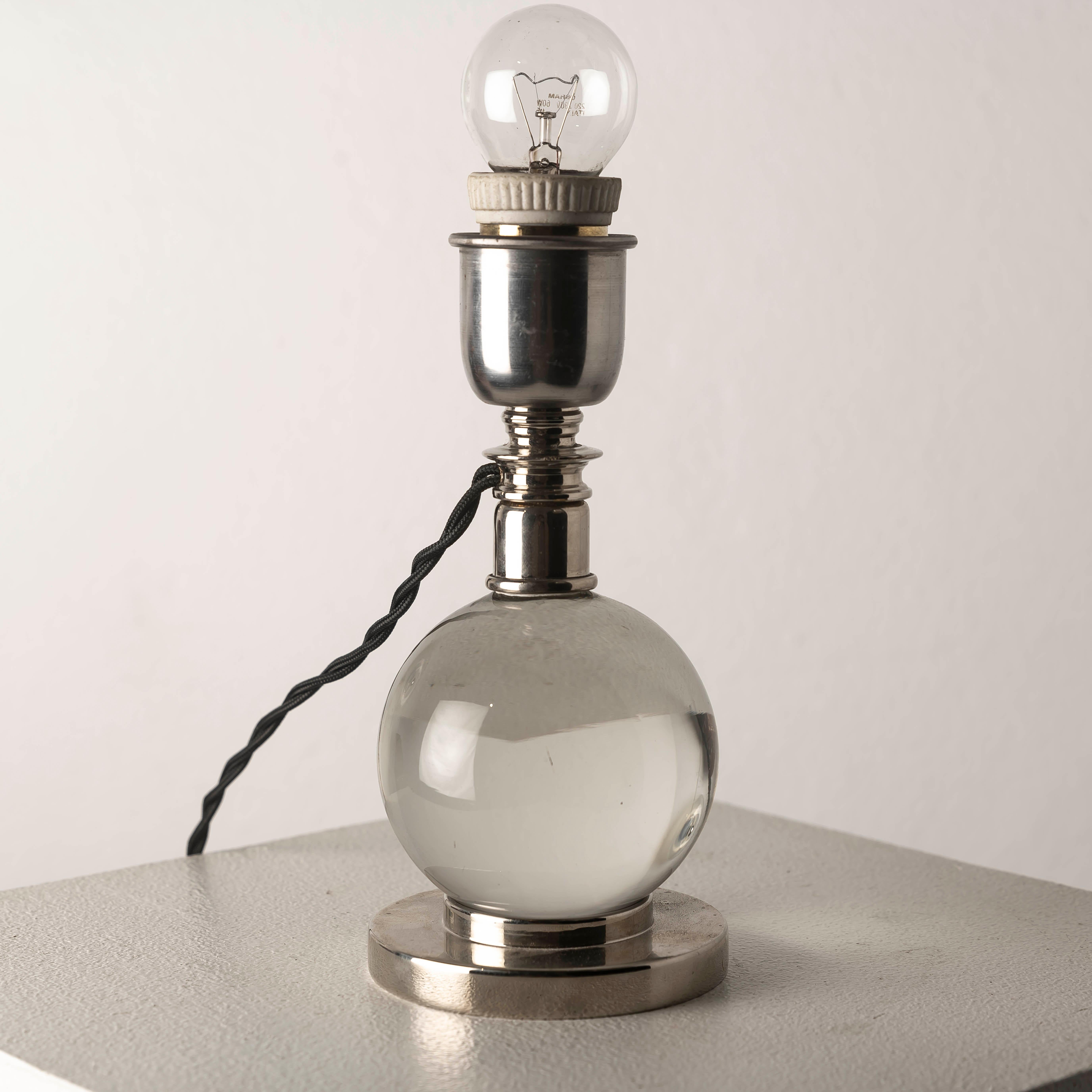 An exceptional example of French Art Deco elegance, this adjustable table lamp Model 7706 was designed by the renowned Jacques Adnet for Baccarat in the 1930s. Crafted in nickel-plated bronze with a solid crystal sphere base, it embodies the refined