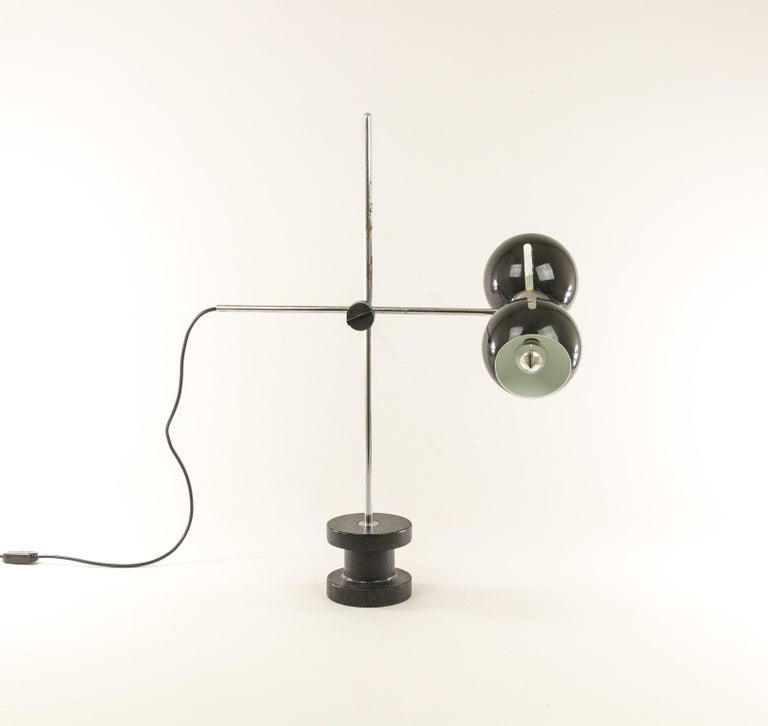 Fully adjustable table lamp manufactured by Italian lighting specialist Valenti, probably in the 1970s.

By loosening the black rotary knob, the position of the swivel arm can be changed. In addition, the black caps can also be turned in all