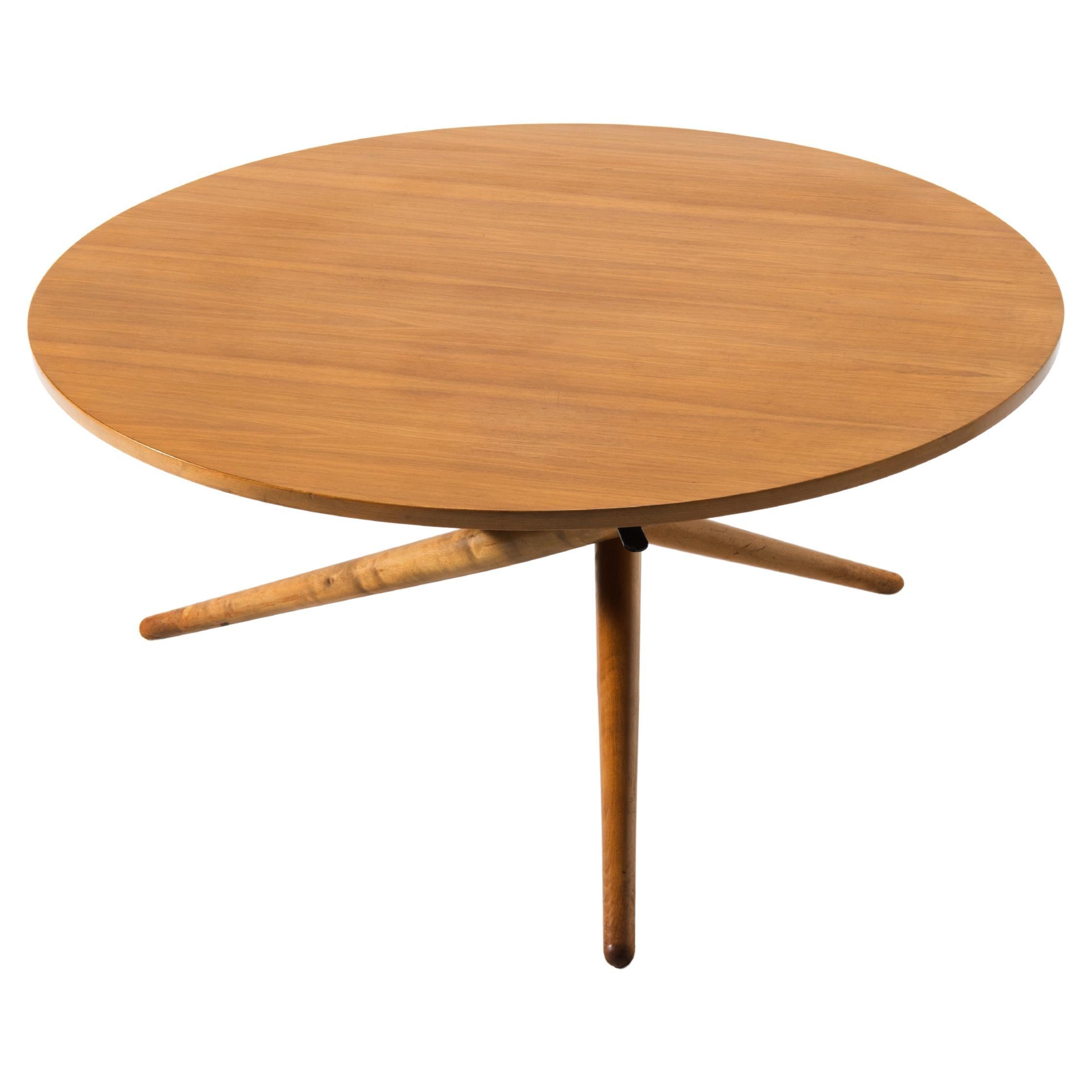 Une table ronde en bois de noyer avec des pieds en hêtre. Cette 