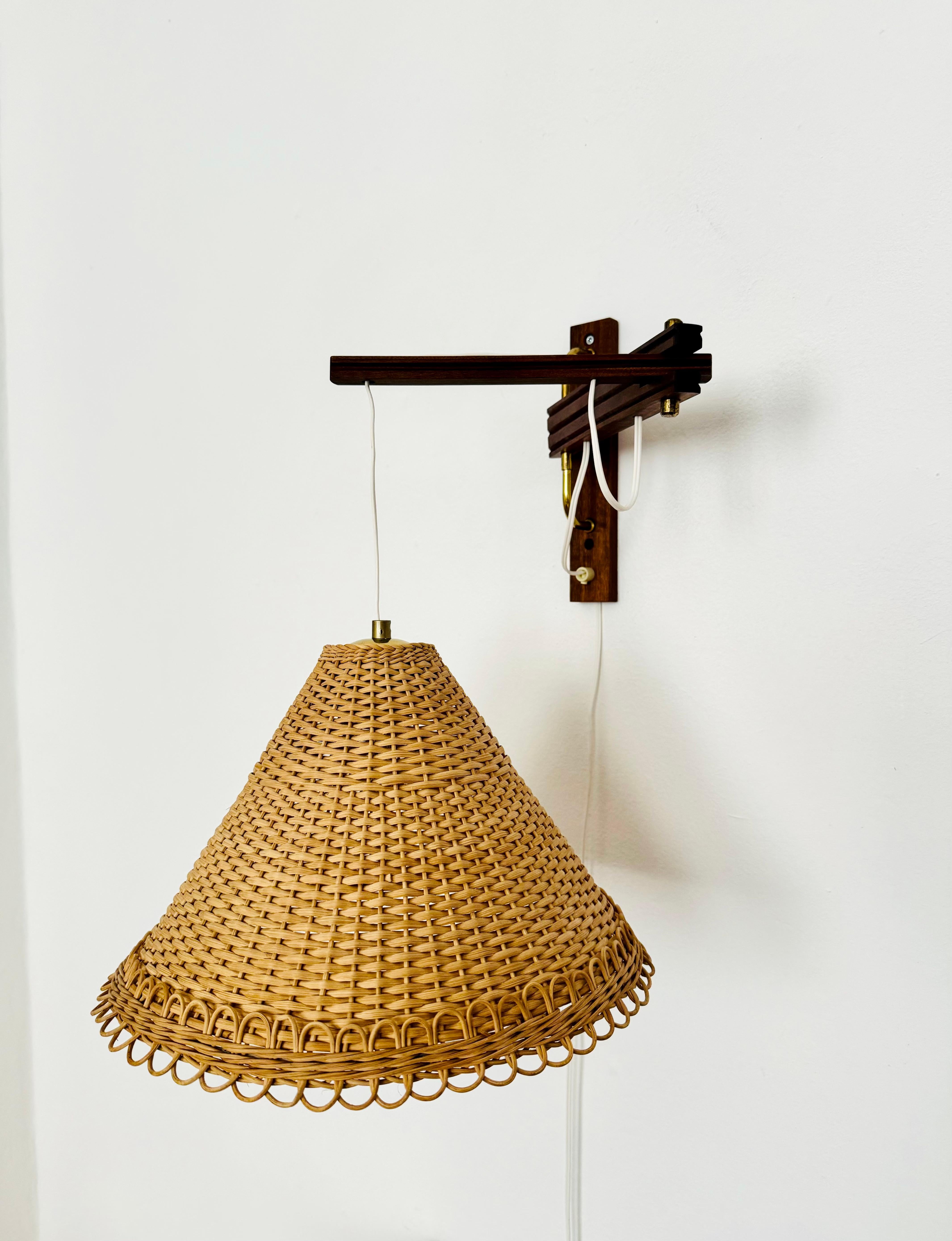 Wonderful Danish teak wall lamp from the 1960s.
Great and unusual design with a fantastically elegant look.
Very nice swiveling teak arm.
The rattan lampshade creates a very cozy atmosphere.

Condition:
Very good vintage condition with slight signs
