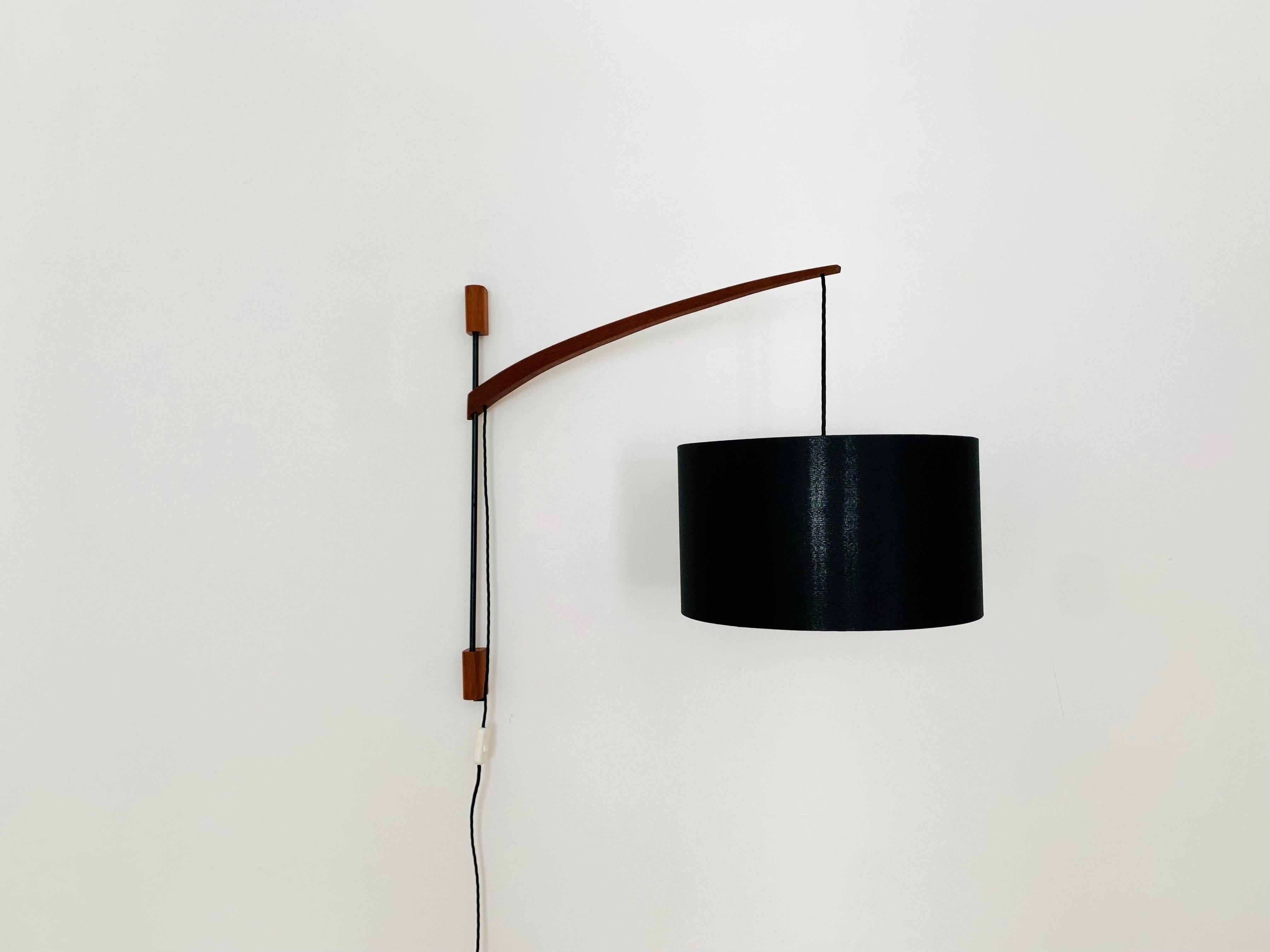 Wonderful adjustable arc wall lamp from the 1960s.
Great and exceptionally minimalistic design with a fantastically elegant look.
Very nice swiveling teak arm.
The lampshade creates a spectacular play of light and creates a very cozy