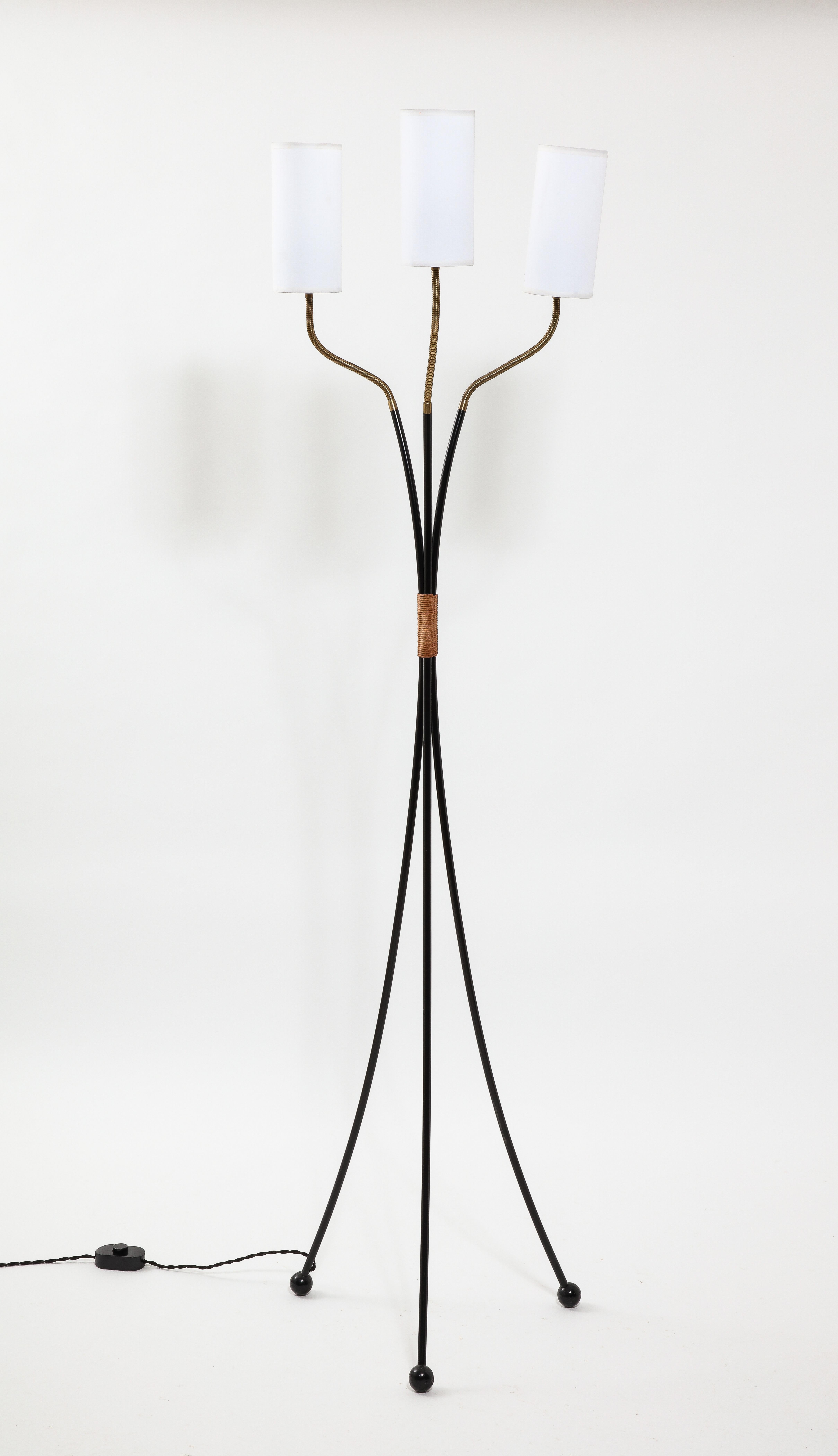 Adjustable tripod floor lamp in black enameled iron and brass. with a leather handle.