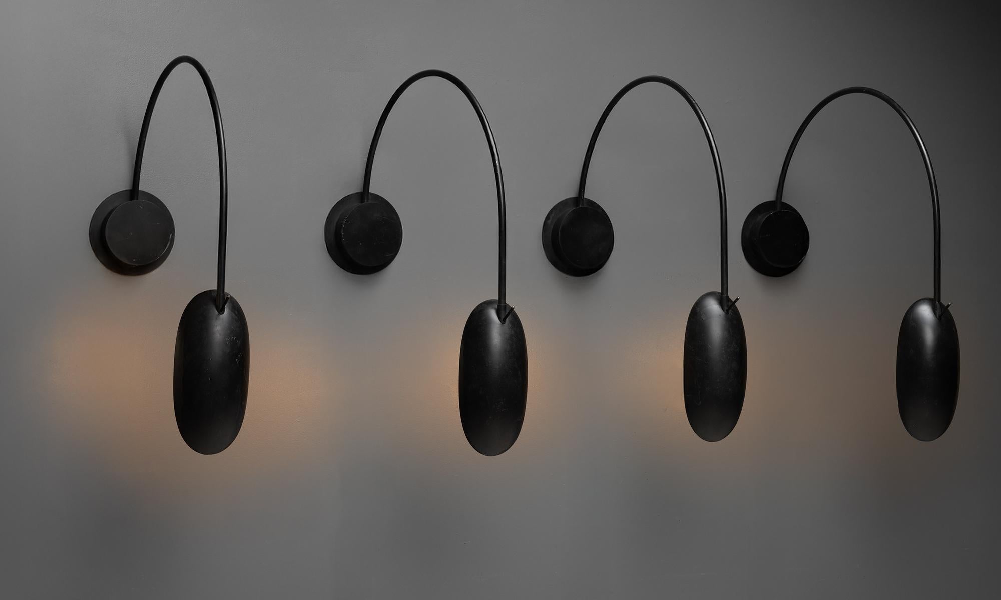 Curved black metal wall lights with pivoting arm and shade manufactured in Italy.