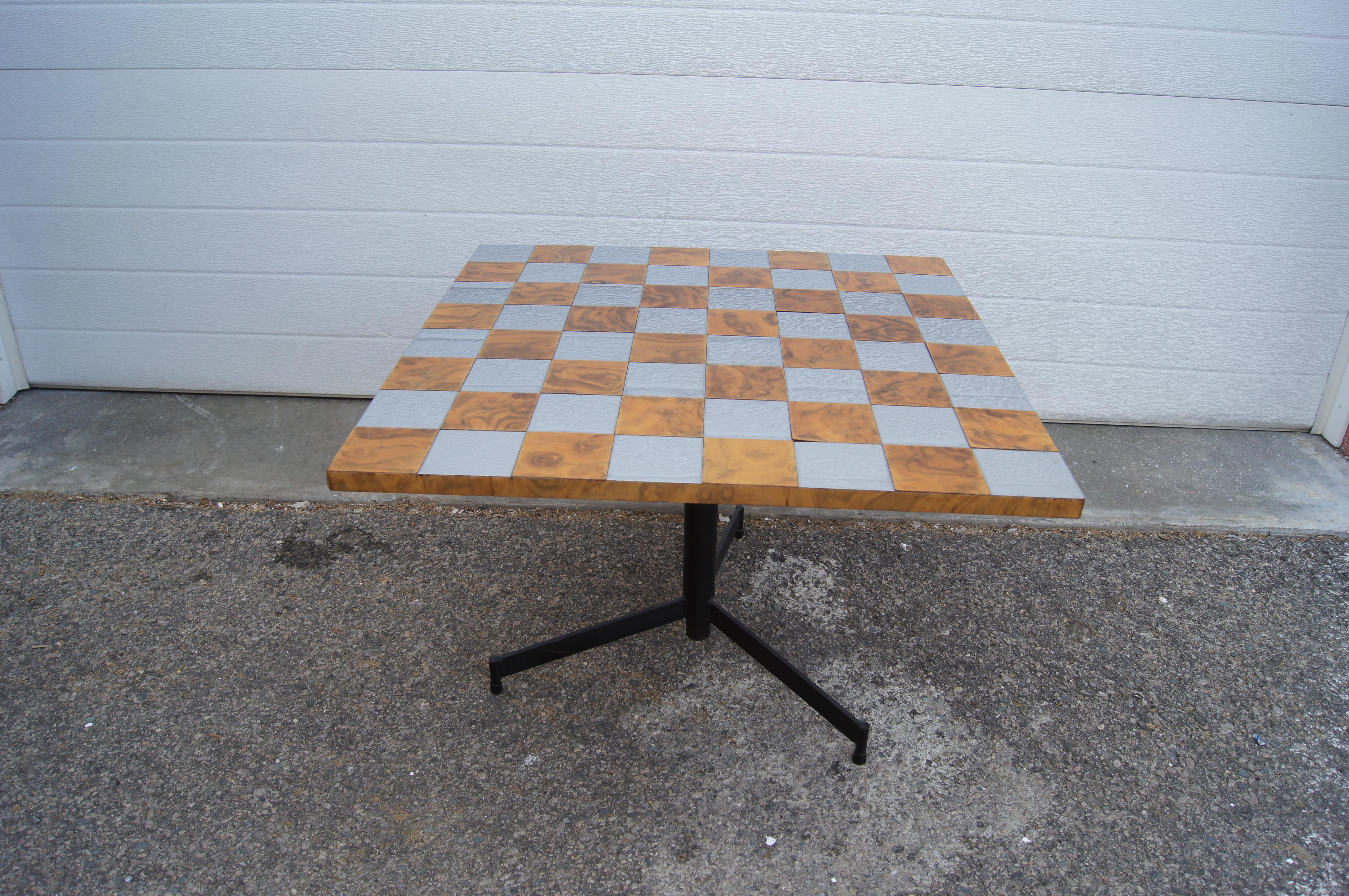 This 1970s side or game table places a Paul Evans–style checkerboard of chrome and walnut burl on an adjustable iron tripod base. The table top can be set as low as 17.5 inches and as high as 29 inches.