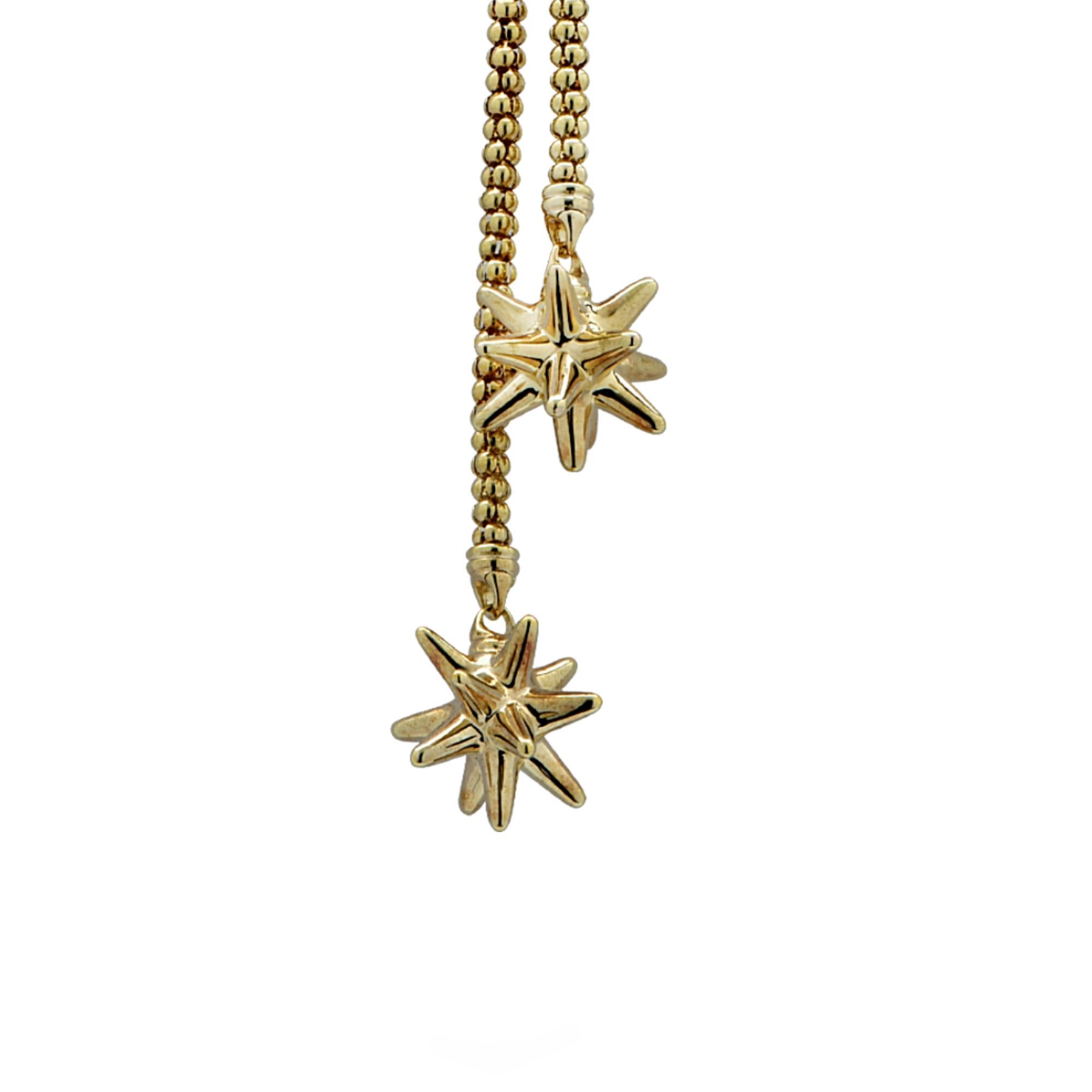 Exquisite adjustable lariat necklace crafted in yellow gold measuring 28 inches in length. This simple, but elegant necklace features a gold beaded necklace with gold starbursts on both ends, threaded through a secure clasp which allows you to