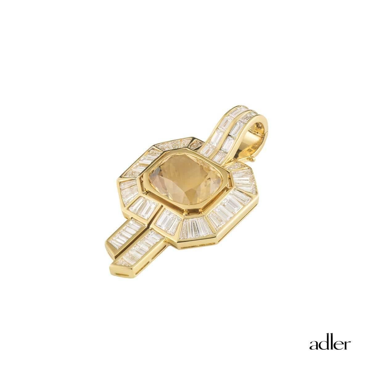 A substantial 18k yellow gold diamond and citrine Adler pendant. The pendant comprises of a cushion cut citrine approximately 12ct with a yellowish-brown hue throughout. Complementing the pendant are a halo of baguette cut diamond with 2 columns in