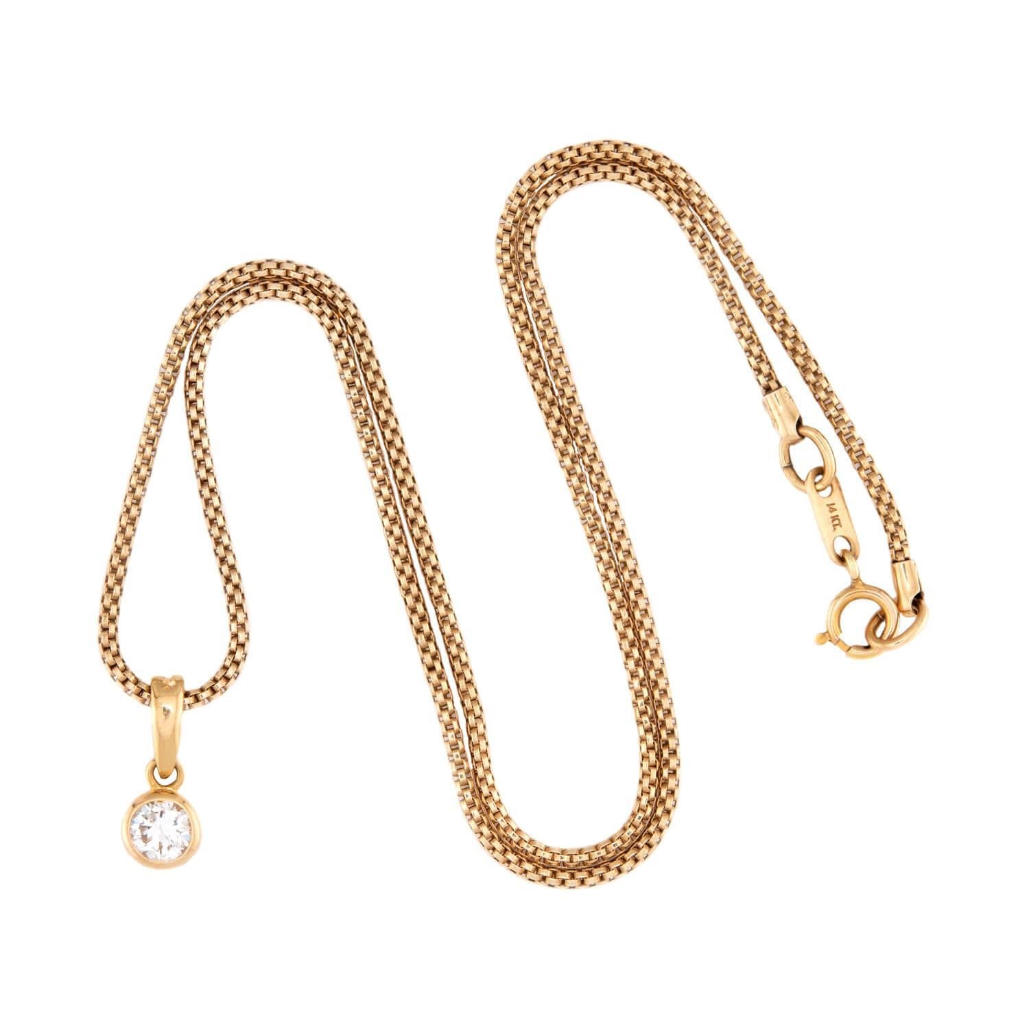 Una bellissima e intramontabile collana con ciondolo di diamanti! Realizzata in oro giallo 18 carati, questa collana inizia con una bella catena a serpente, che si chiude con una semplice fibbia a molla con la scritta 