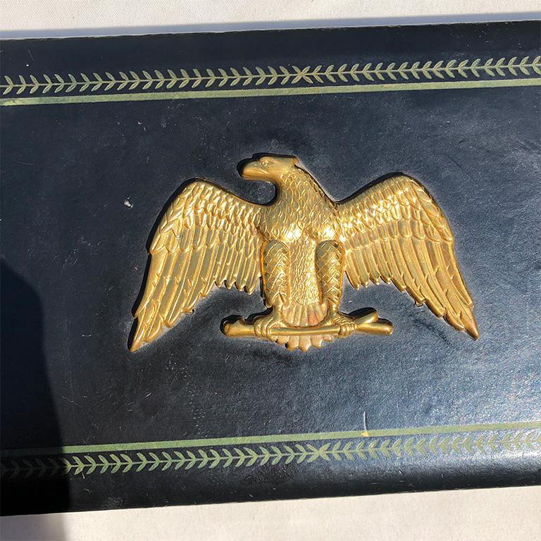 Rectangular black valet box with brass eagle affixed upon the lid. Inside is lined with a plush velvet with space for jewelry, cuff links, or any other items that need a safe beautiful place to store your favourite pieces.

We see this piece upon
