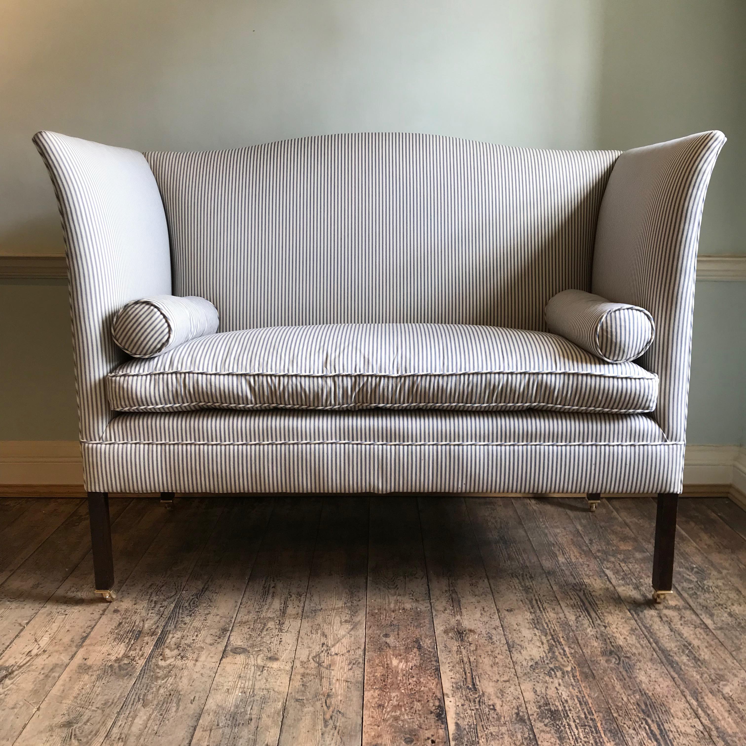 The Admiral sofa by Noble and Thane - adapted from an elegant English wingback design. 

Shown here in full rigging, with optional brass castors and bolster cushions, finished in a vintage style navy and white striped ticking.

Both the frame