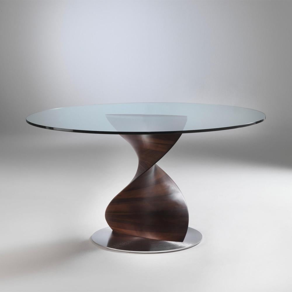 Table ADN round with base hand carved in solid
polished walnut wood. With Tempered glass top,
12mm thickness. 
Base dimensions: Diameter 66cm x height 74cm.
Available on request in:
Diameter 130cm x height 74.5cm, price: 15900,00€.
Diameter 140cm