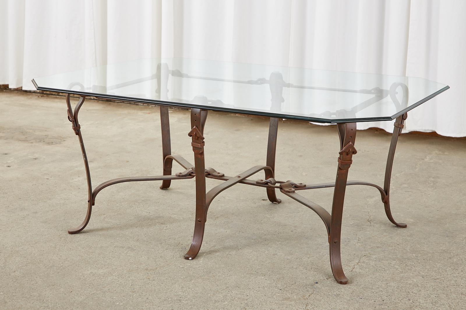 Mid-Century Modern French cast iron coffee or cocktail table featuring a faux leather equestrian strap design in the manner and style of Jacques Adnet and Hermes. The iron frame was beautifully crafted to resemble leather equestrian harness straps,