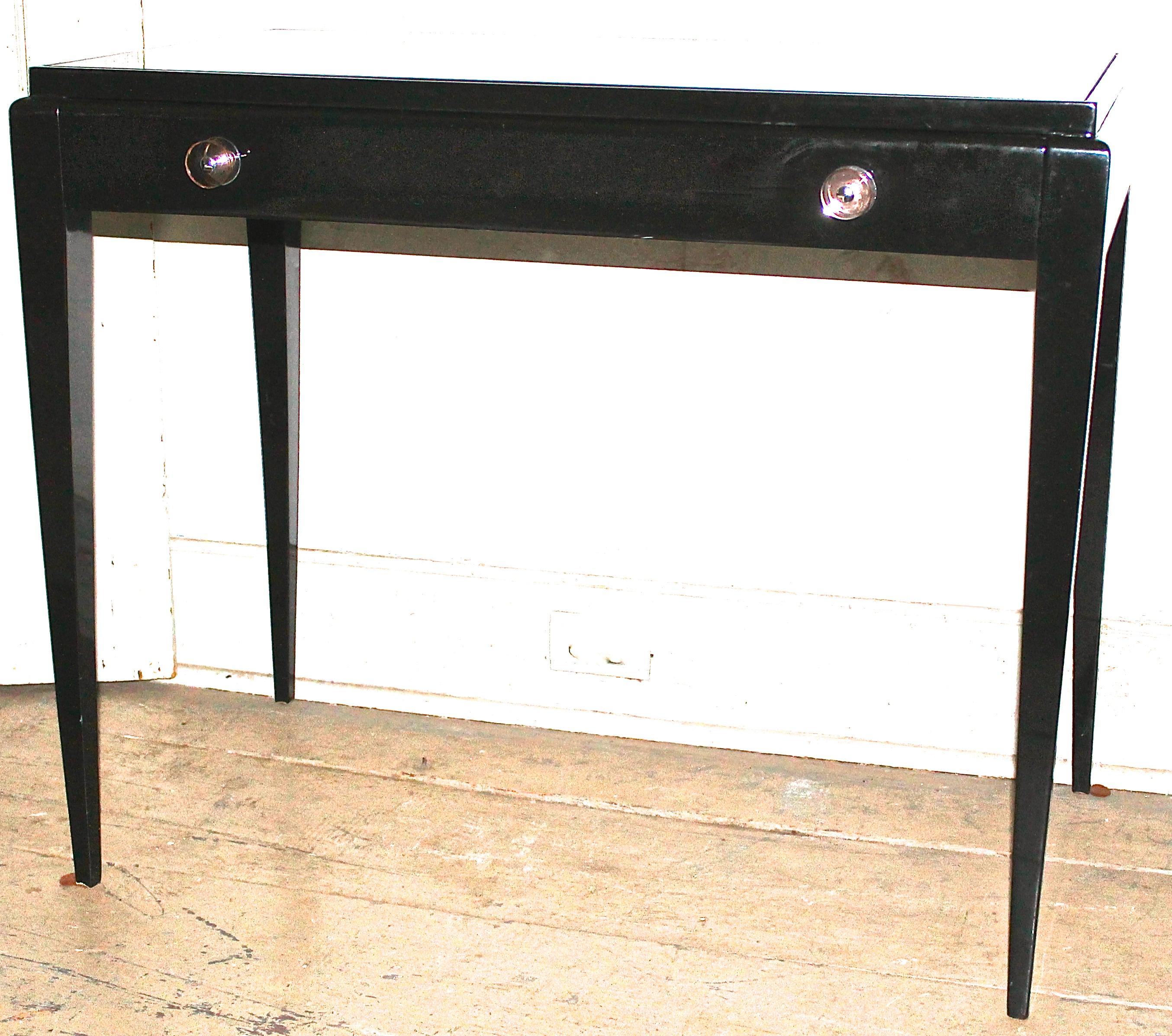 Simple tapered lines, one narrow draw with amazing Lucite and chrome pulls. The desk surface is a black glass inset. In very pristine condition being recently re lacquered.