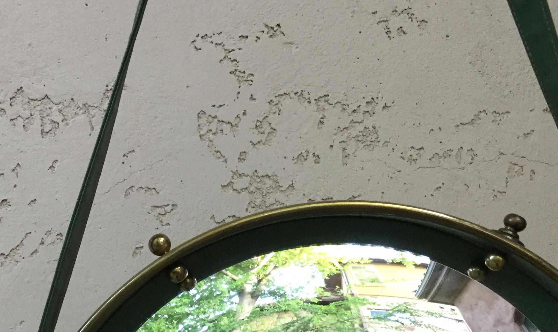Midcentury French round convex mirror in the style of Jacques Adnet. The mirror is framed with brass and decorated with gilt balls suspended with faux leather straps. Mirror with strap: 28