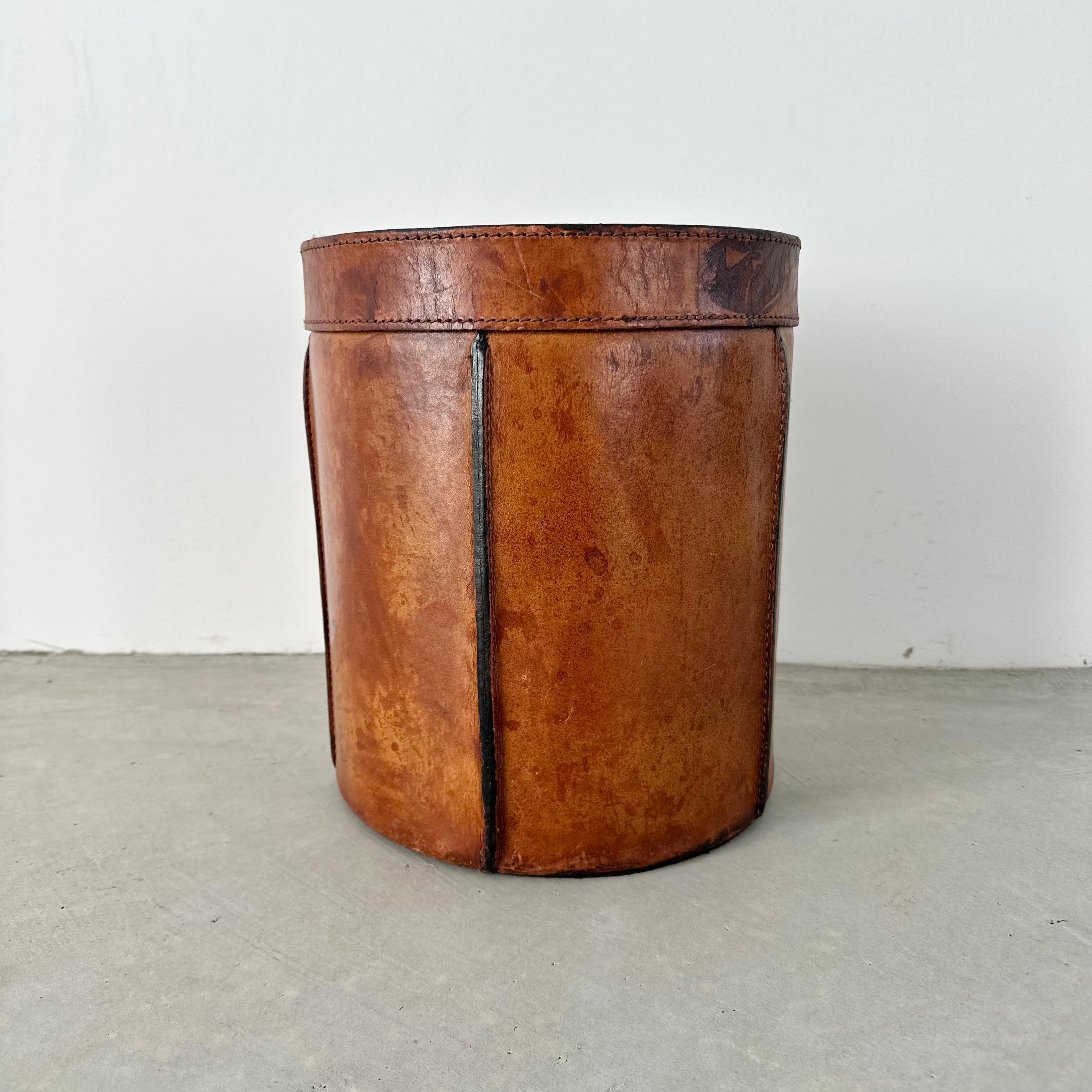 Corbeille à papier en cuir de style Trueing By, dans le style d'Adnet. Produit en France dans les années 1960.

Il suffit d'admirer le cuir pour se rendre compte de la vie qu'a eue cette poubelle. Rare et belle patine couvrant l'intégralité de la