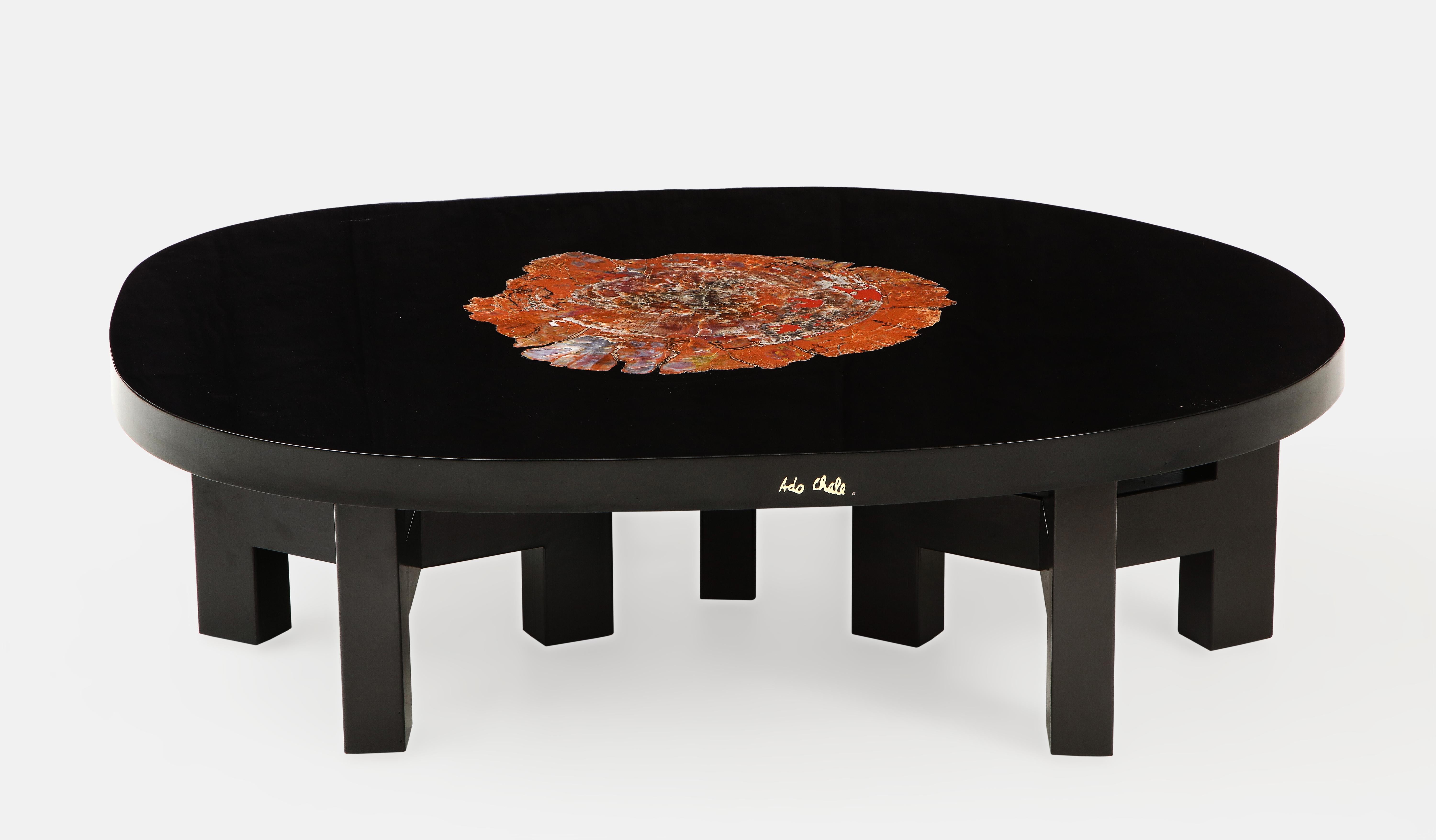 Ado Chale rare coffee table with Arizona petrified Sequoia wood inlaid in thick black lacquered resin tabletop resting on 3 sets of black painted tripod steel brackets, Belgium, 1970s. The Sequoia fossilized wood dating back 250 million years with