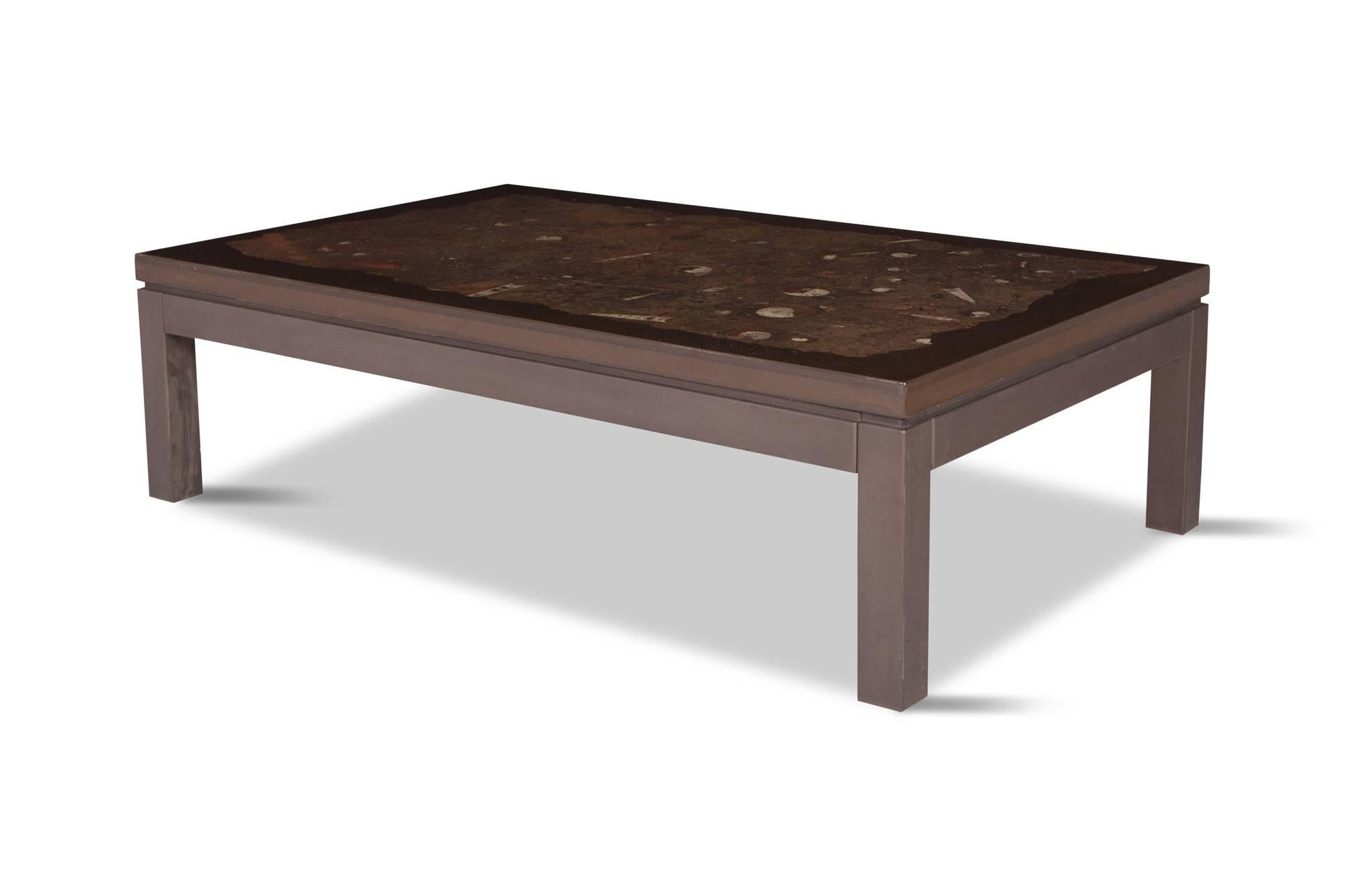 Hollywood regency rectangular coffee table by Etienne Allemeersch, an artisan who worked in the workshop of Ado Chale, in resin with a fossil stone inlay and wooden base. The table top exposes beautiful earthy colours with a variety of fossils and