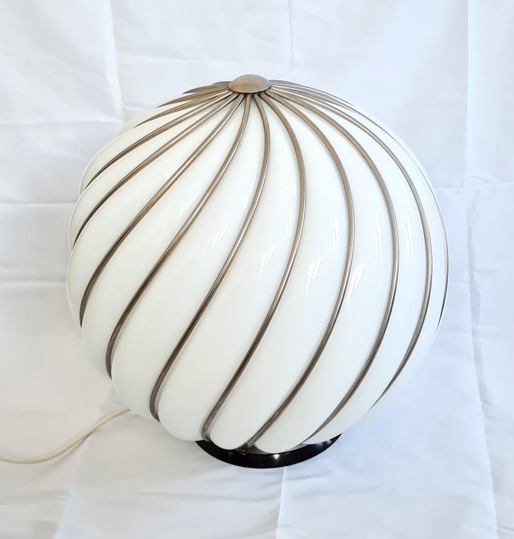 Lampada da terra o da tavolo vintage di VeArt in vetro di Murano bianco e aste in metallo ottonato, anni '60, Italia.
Mentre la base in legno nero presenta una presa E 27 e un interruttore on/off, l'imponente corpo in vetro a forma di alveare mostra