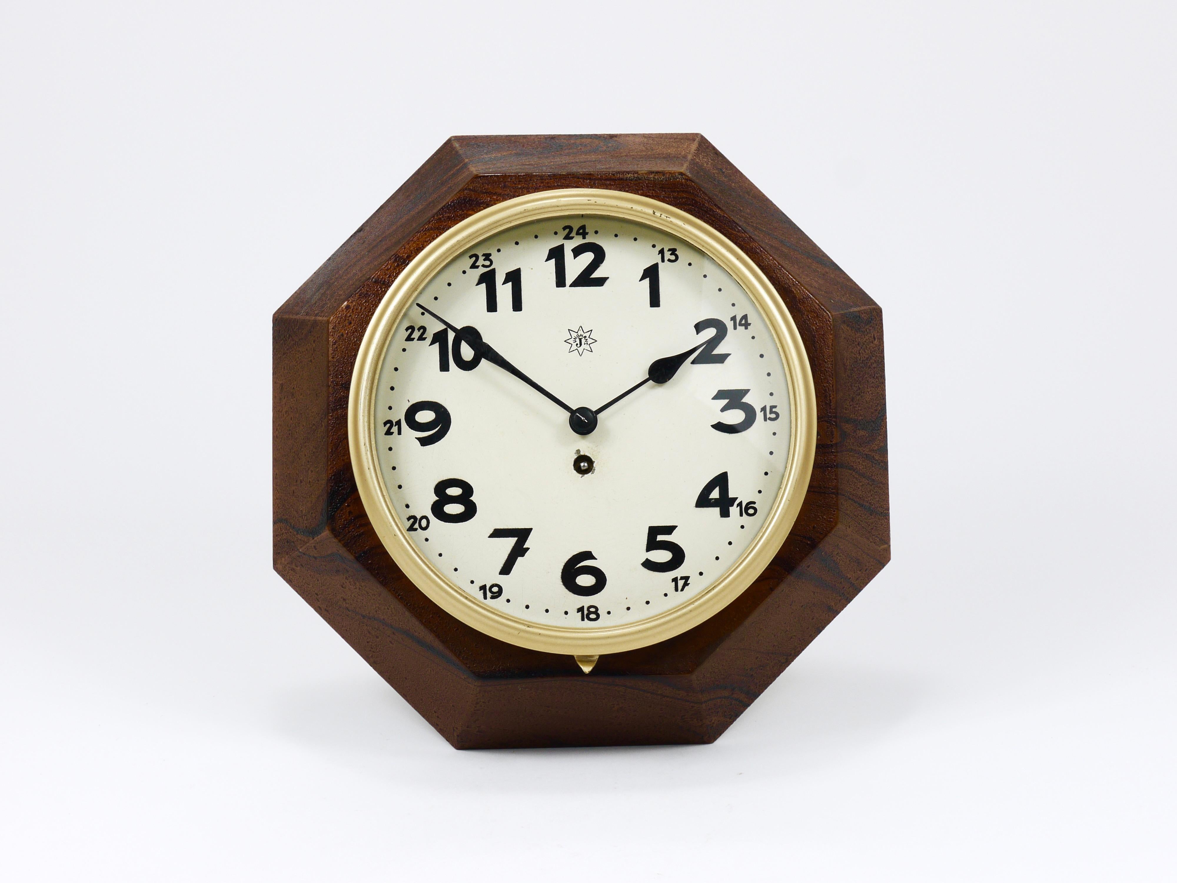 Une belle horloge murale minimaliste, datant d'environ 1920, conçue par Adolf Loos (1870-1933), fabriquée par Junghans Allemagne. Cette horloge se distingue par son boîtier octogonal inimitable, fabriqué en tôle de fer laquée. Le boîtier est