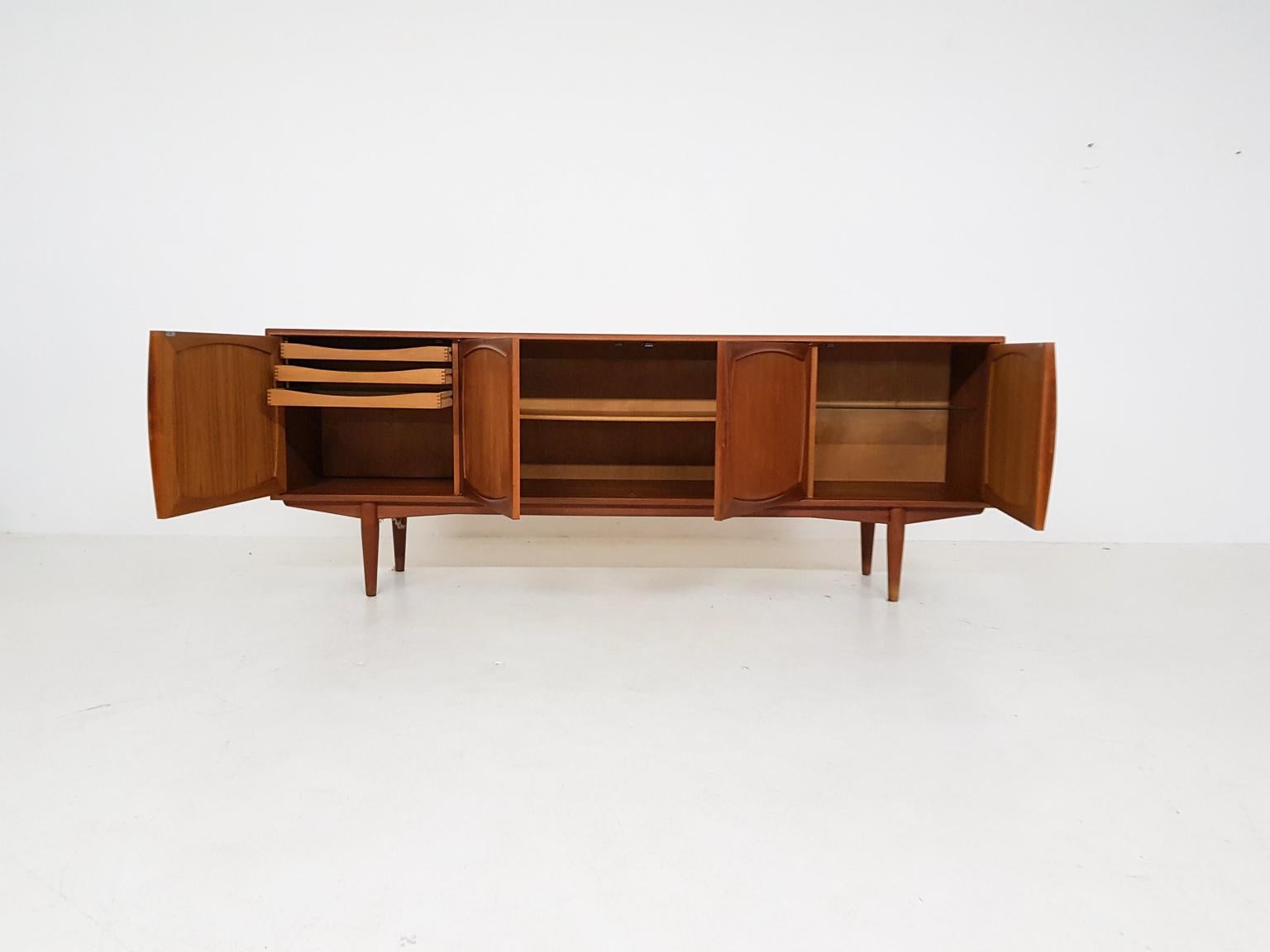 Scandinavian Modern teak credenza or sideboard by Adolf Relling & Rolf Rastad for Bahus, Norway 1960s.

This Scandinavian Modern sideboard form Norway is entirely made of teak. It has 4 doors with beautiful solid teak inlays. Inside the cabinet