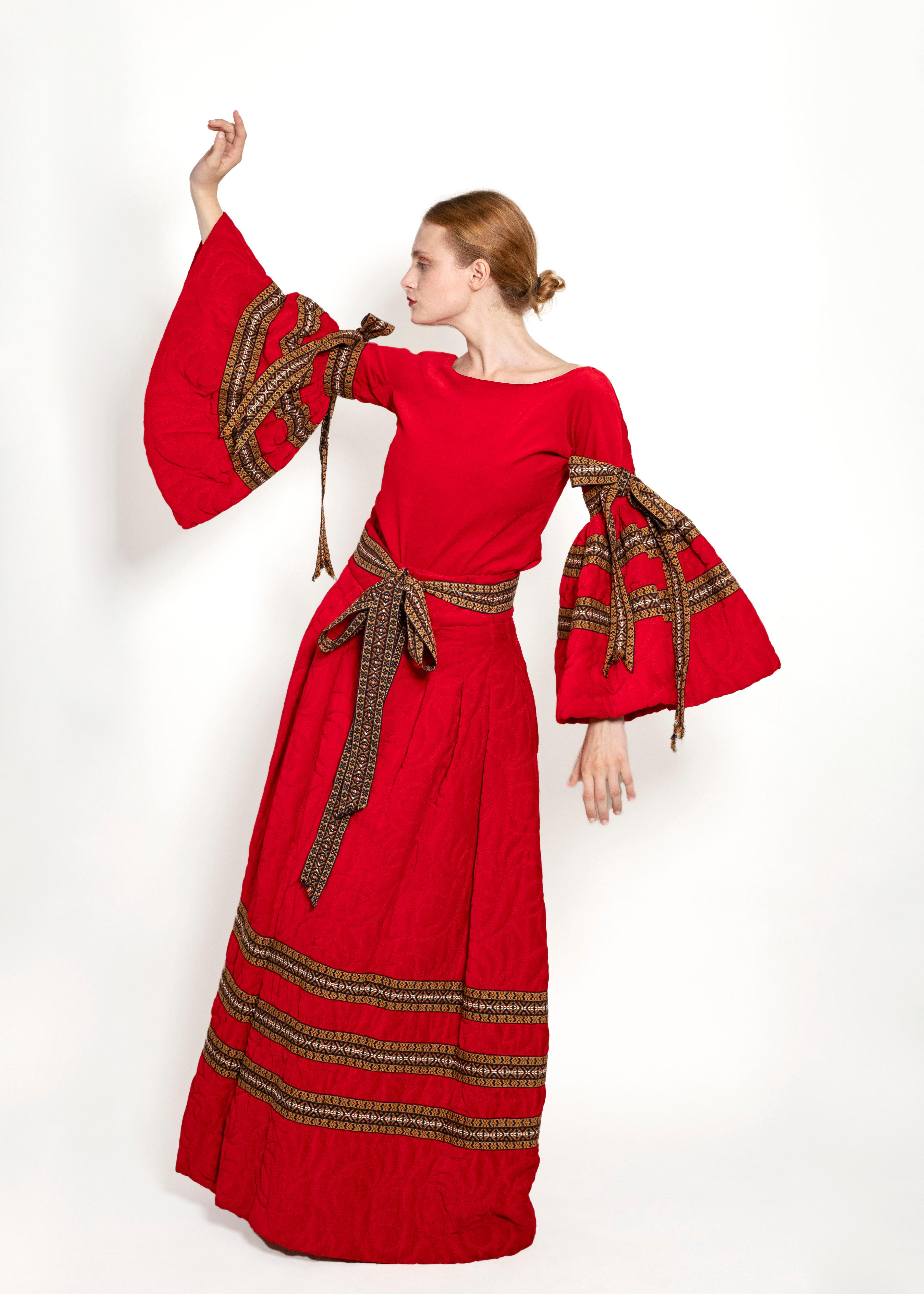 Worn by Aretha Franklin for her Spanish Harlem album cover in 1971, this iconic Adolfo Skirt ensemble is intricately designed with ruby-red embroidered velvet with colorful ribbon trim. The bell sleeved top has colorful ribbon arm ties, and the